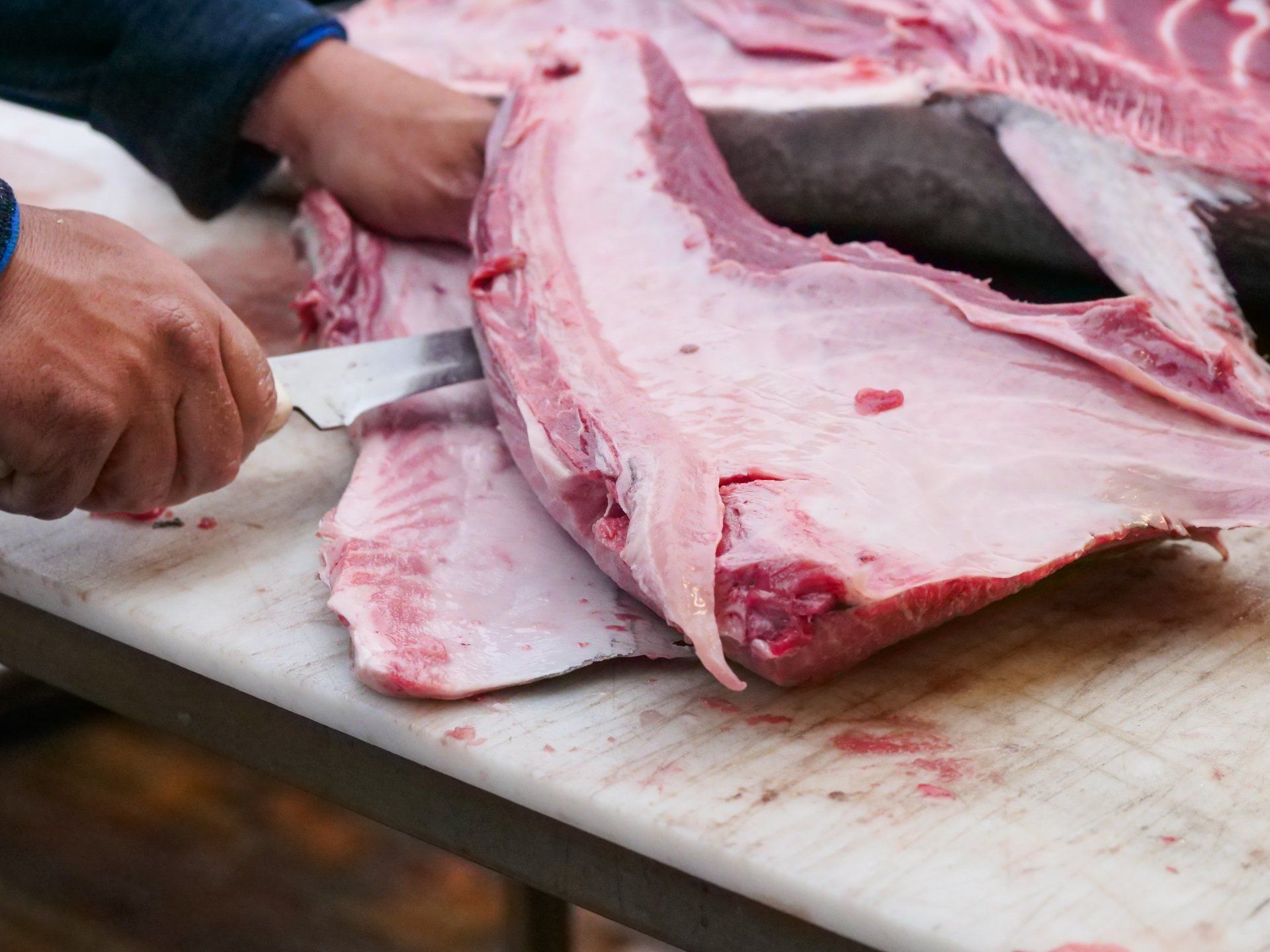 Person preparing a large piece of meat