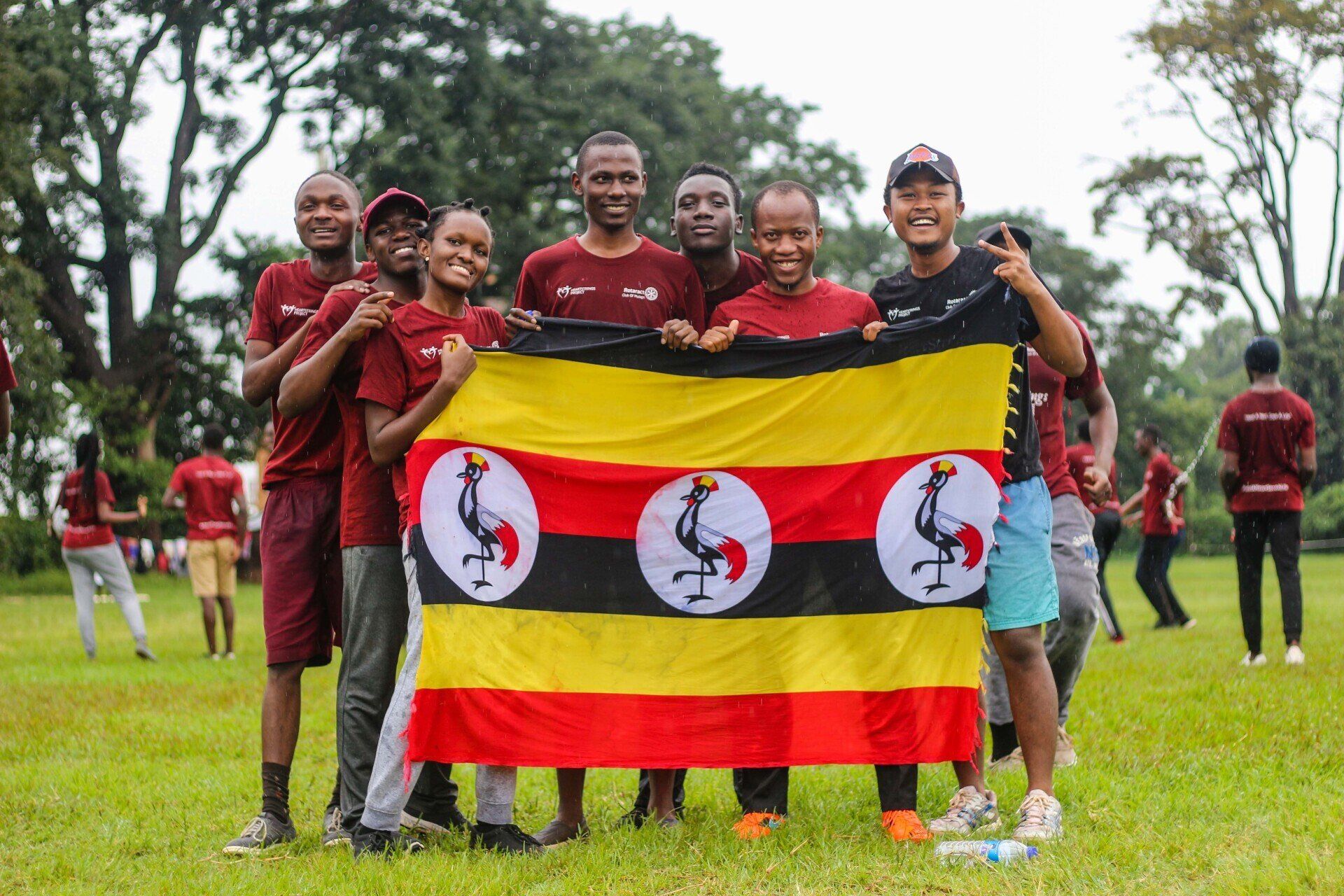 A group of people are standing in a field holding a flag.