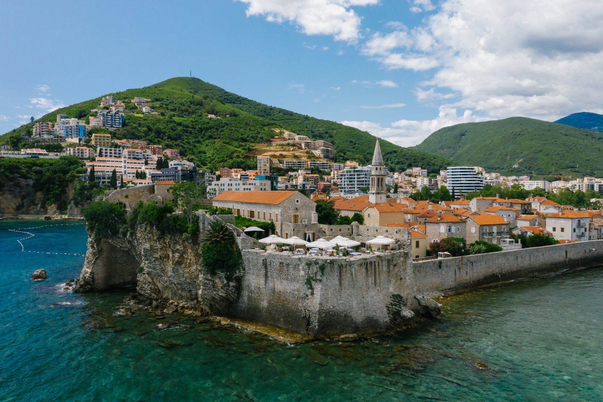 An aerial view of a city on a small island with a seawall.