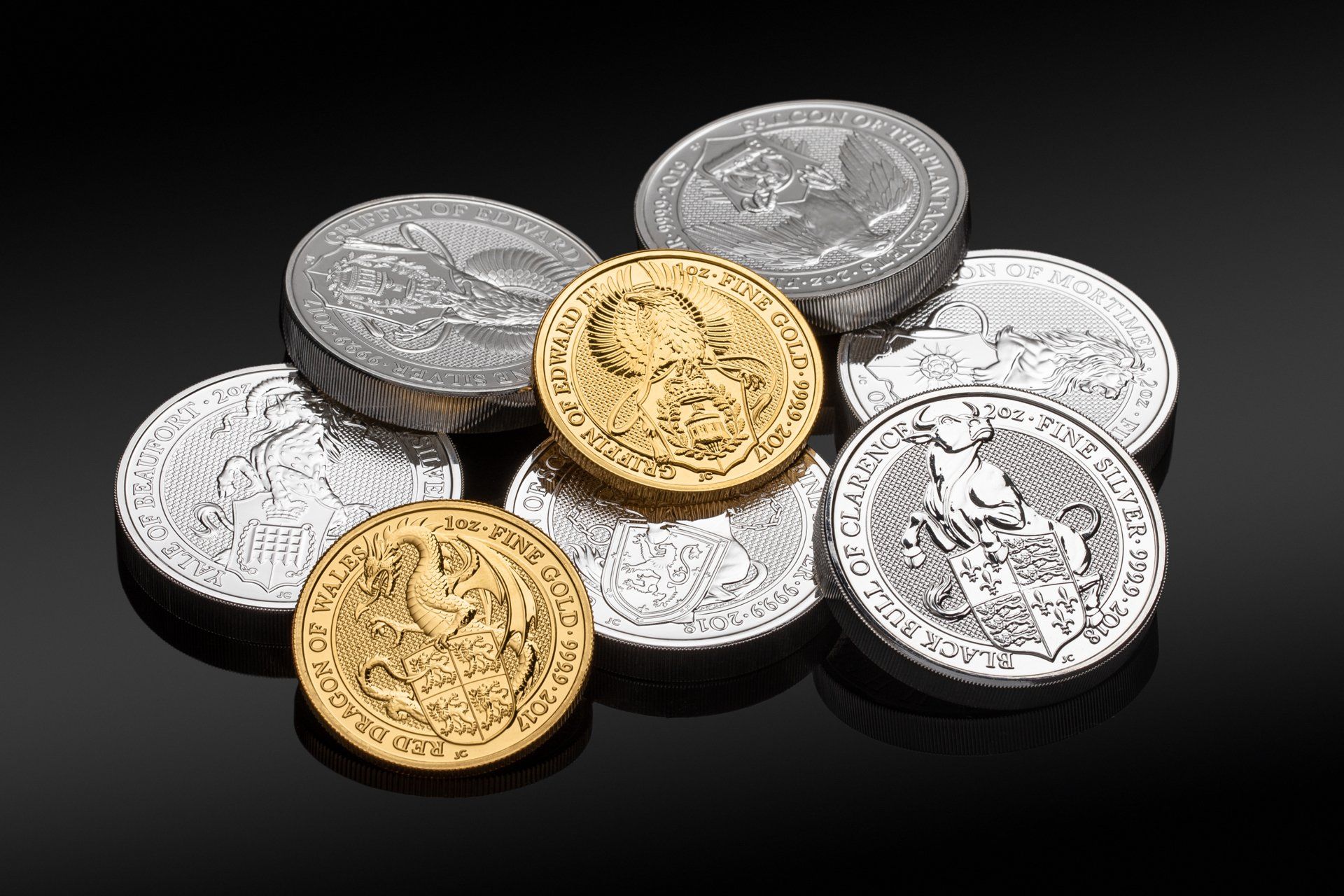 A pile of silver and gold coins on a black surface