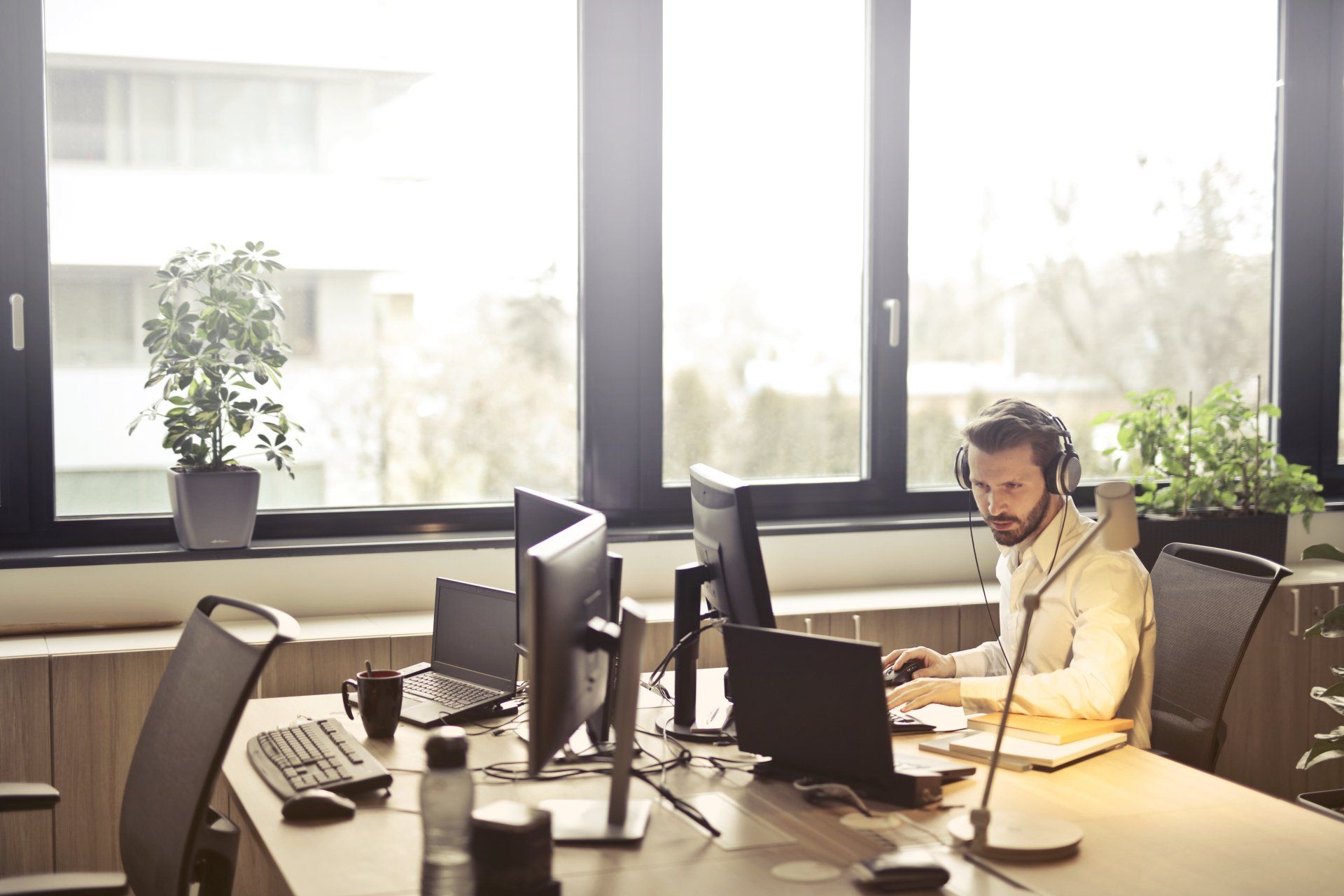 a man wearing headphones is sitting at a desk in front of a computer