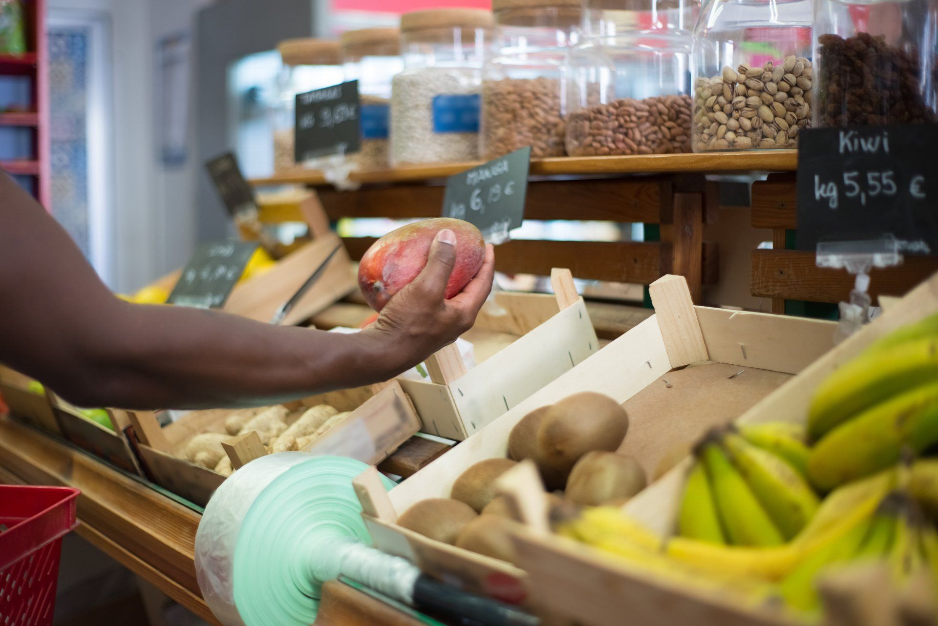 A person is holding an apple in a grocery store.