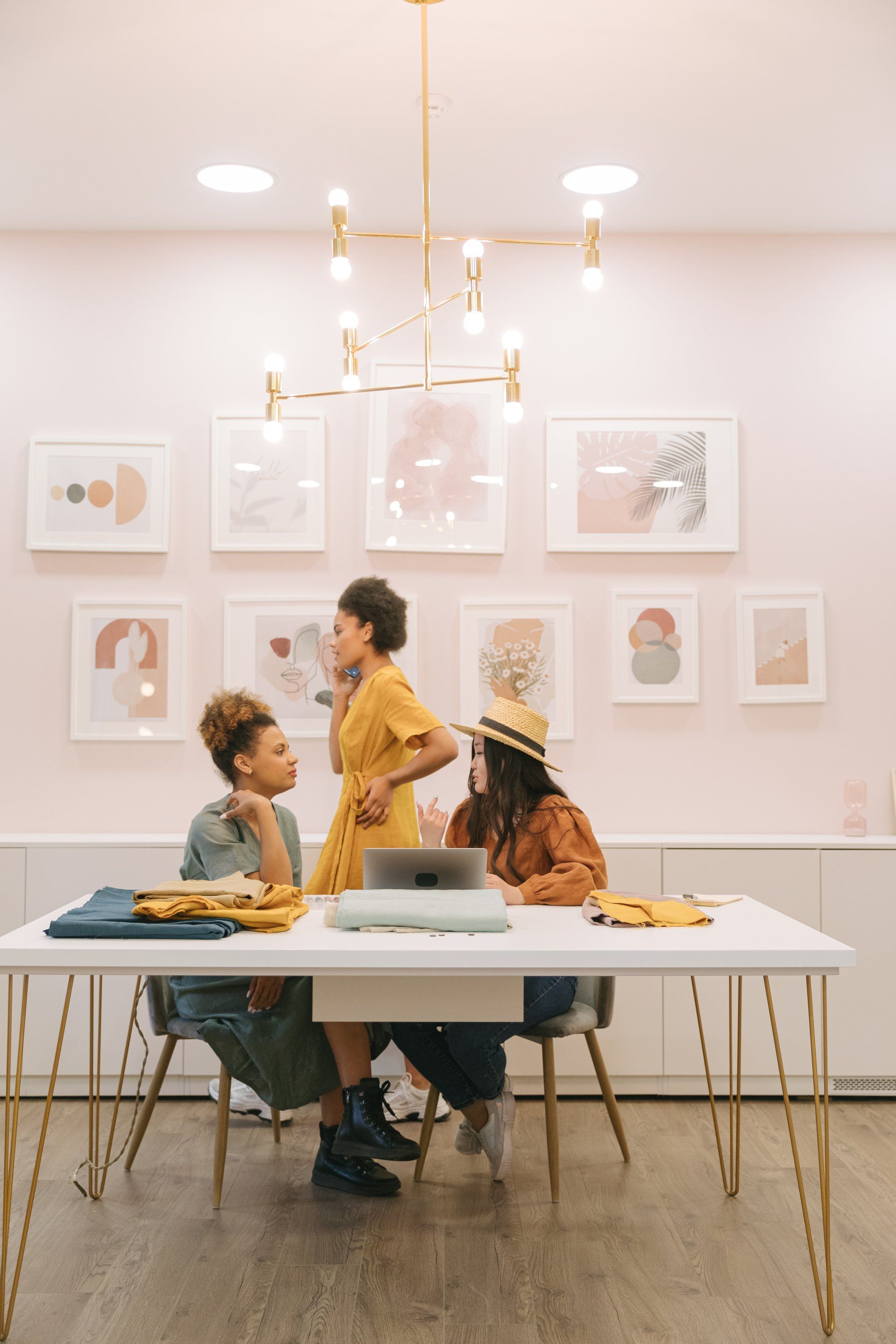 Three women are sitting at a table talking to each other.