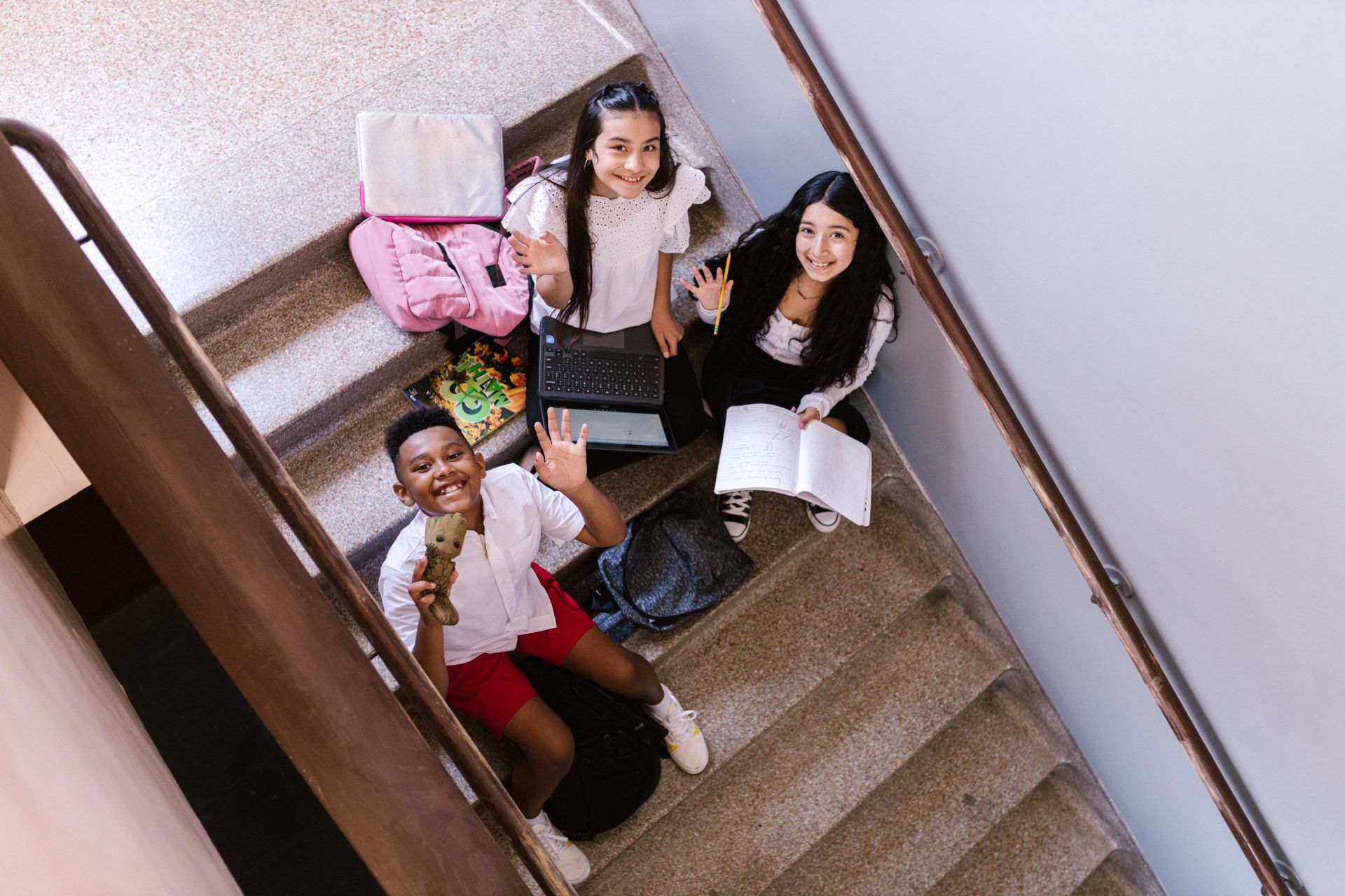 A group of children are sitting on a set of stairs.