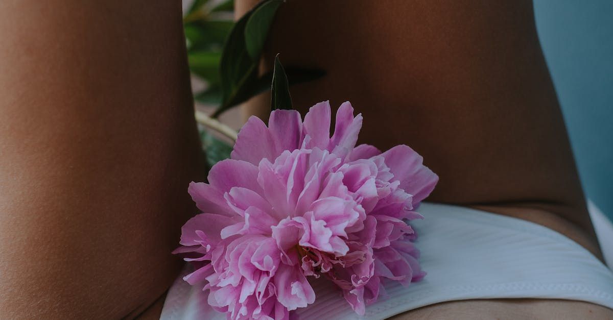 a close-up of a woman's groin with a pink flower on it.