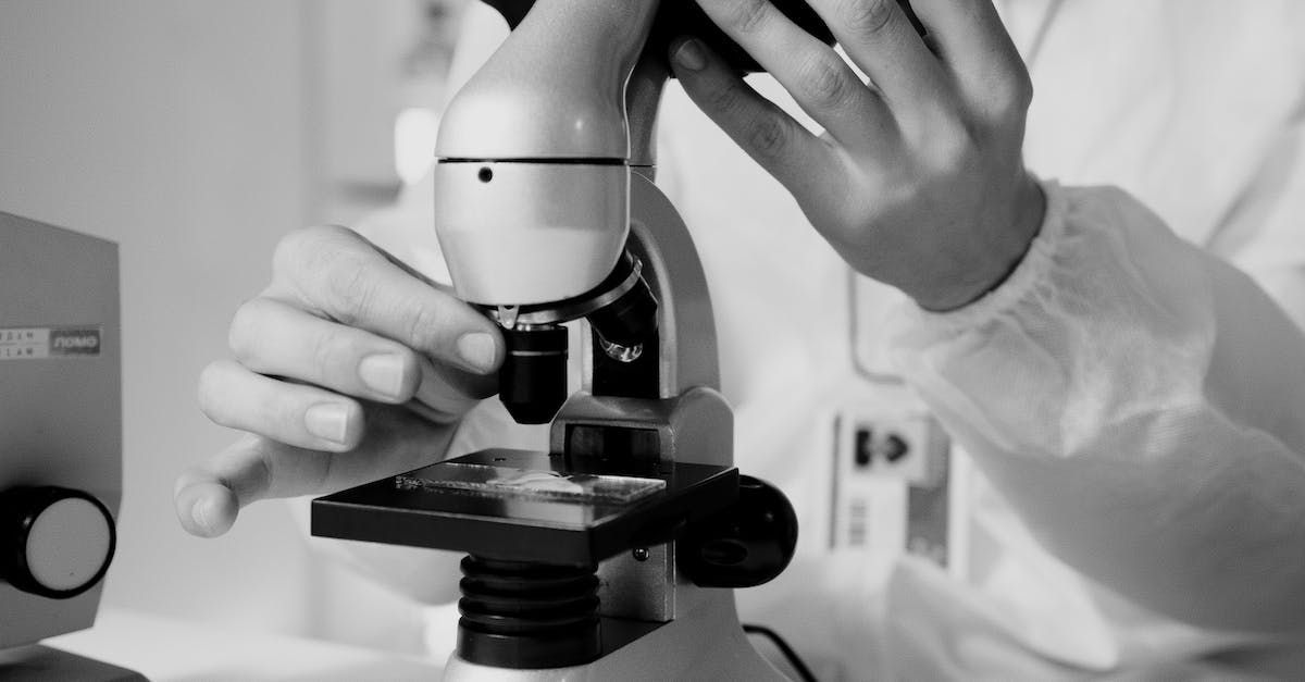 a person is looking through a microscope.