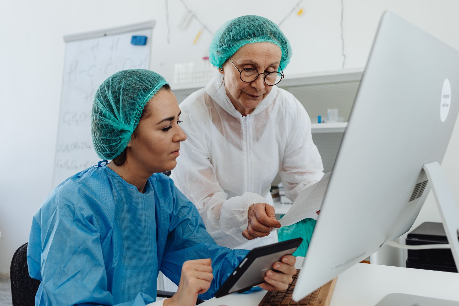 Two female doctors are looking at a computer screen.