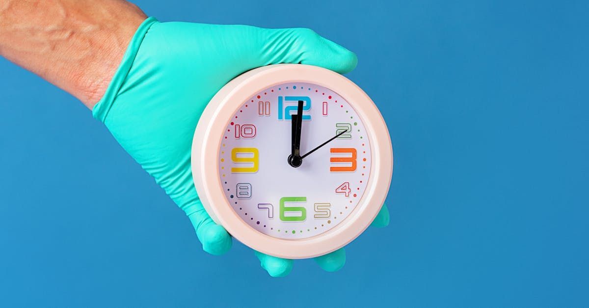 Hand with a surgical glove on holding a clock