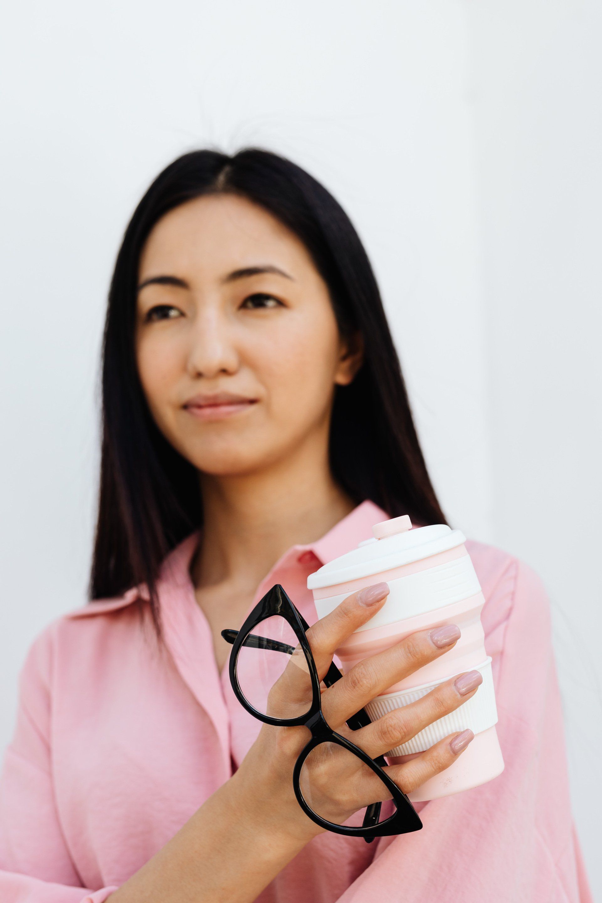 A business woman holding a cup that says 