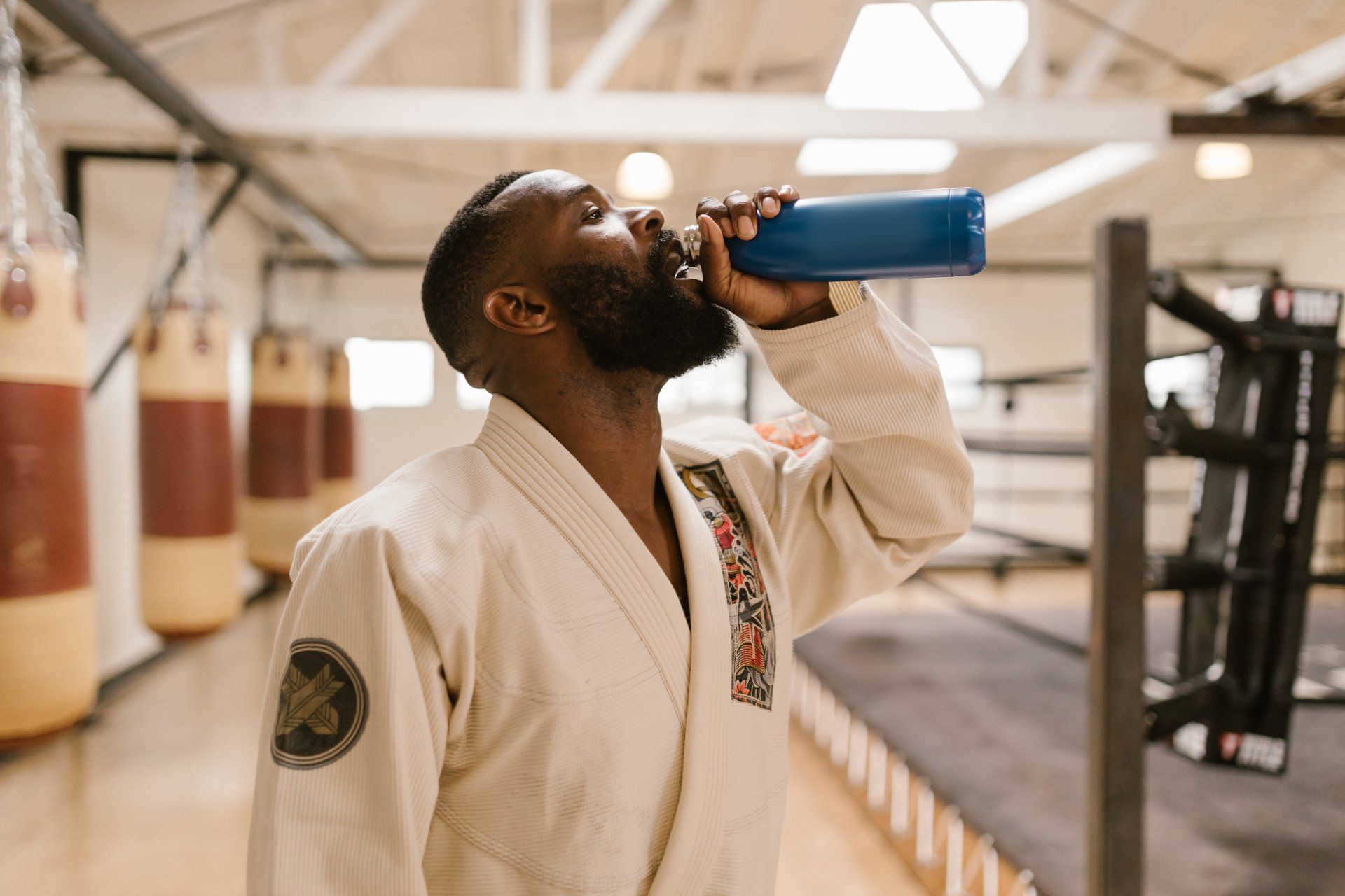 a man is drinking water from a bottle in a gym .