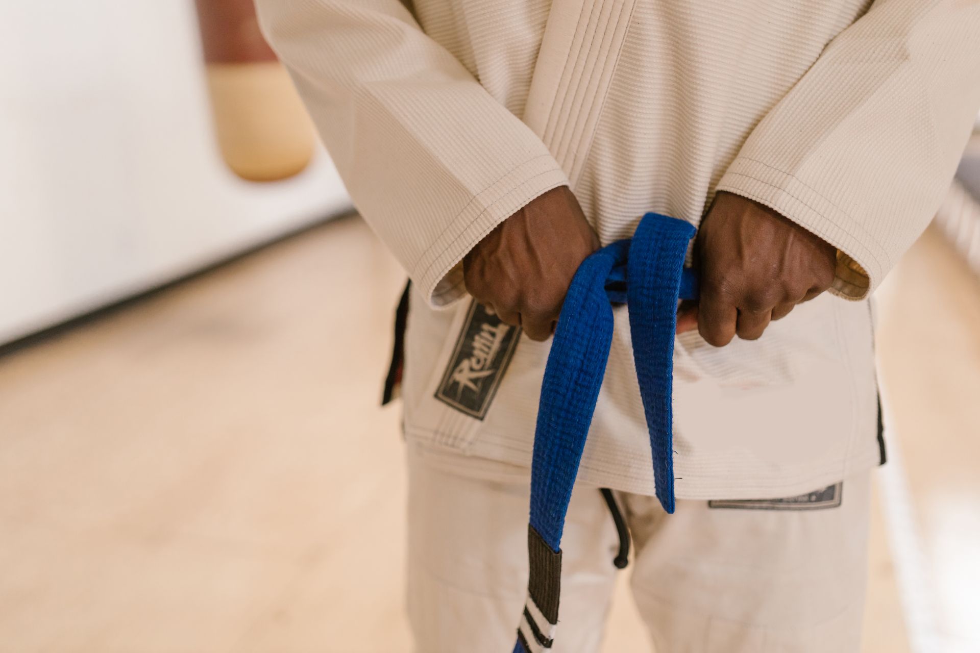 Sportler in weißer Karateuniform mit blauem Gürtel