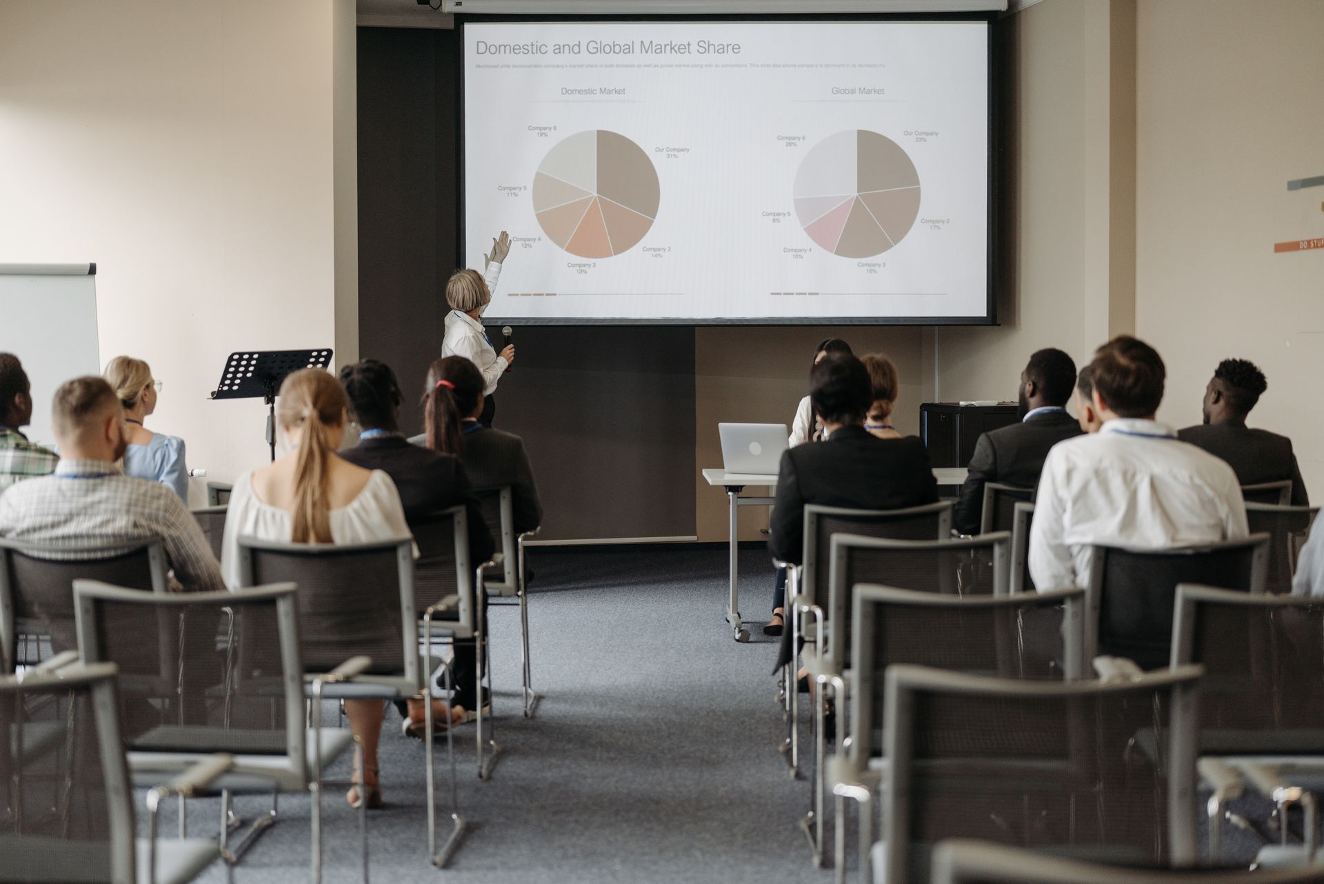 A woman is giving a presentation to a group of people in a conference room.