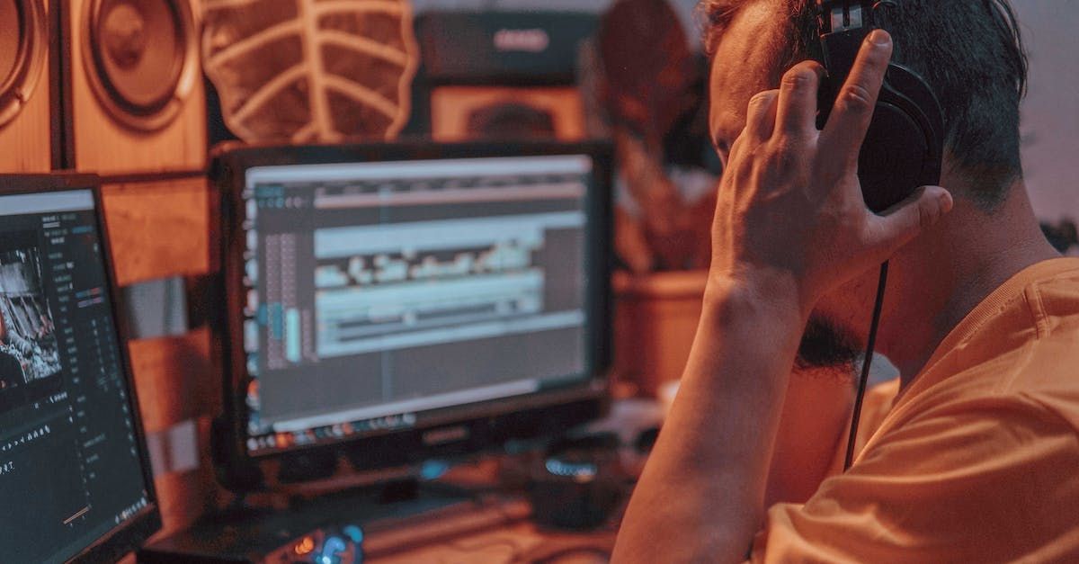 A man wearing headphones is sitting in front of a computer.