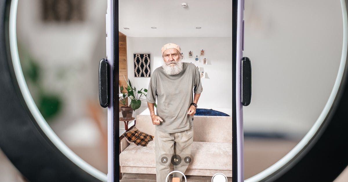 A man with a beard is taking a picture of himself on a cell phone.