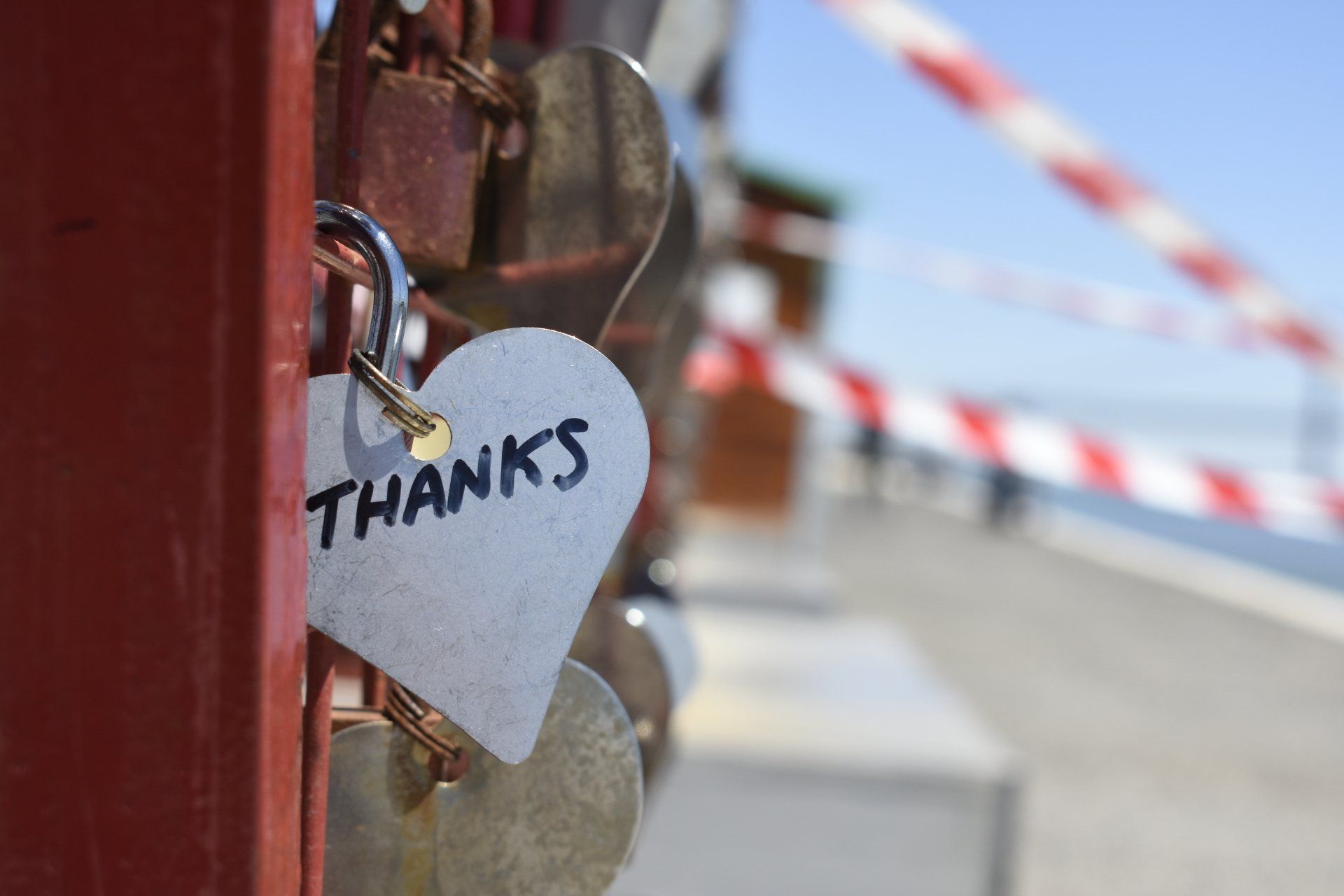 a heart shaped lock with the words `` thanks '' written on it .