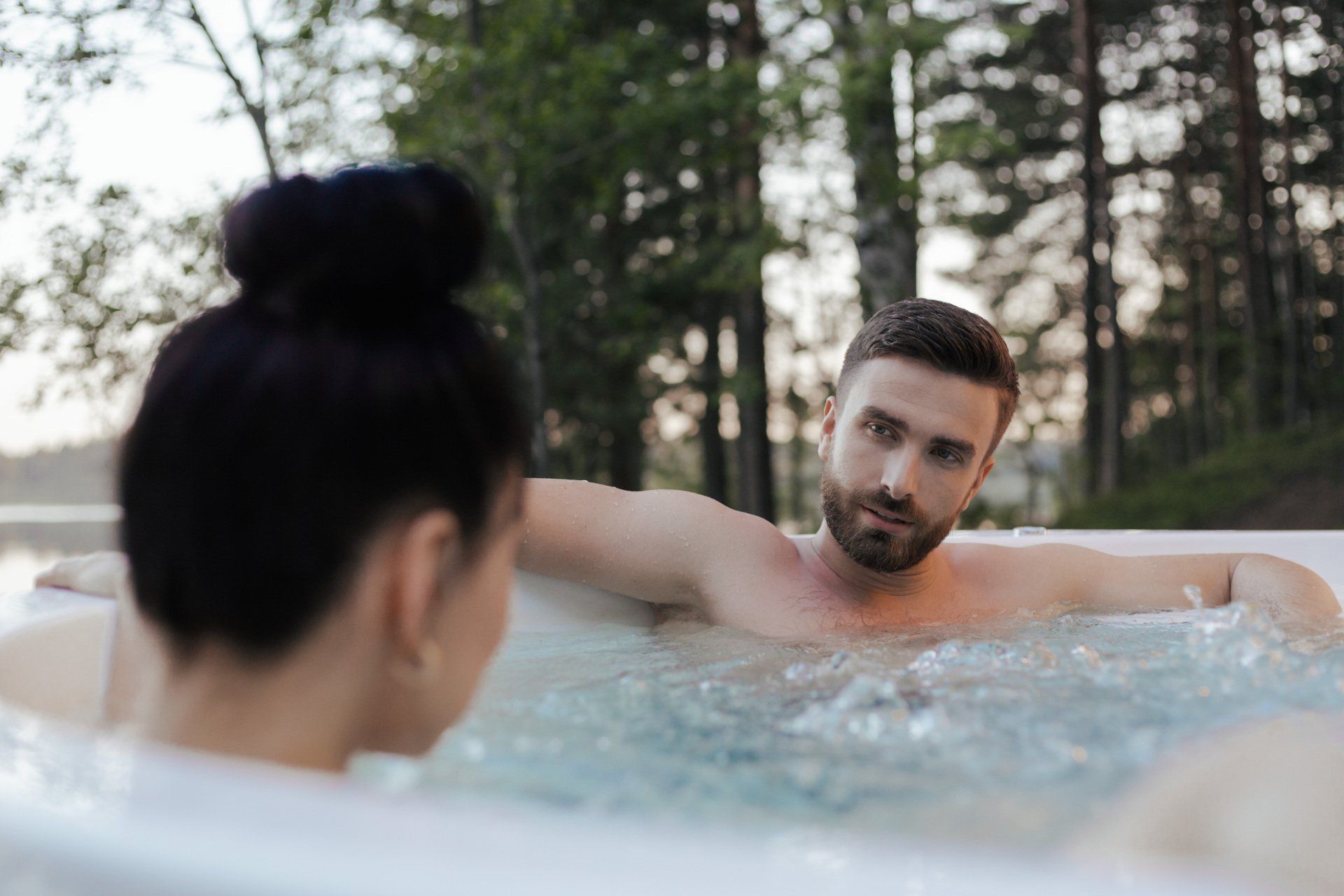 A man and a woman are sitting in a hot tub.