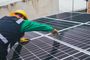 A man is working on a solar panel on a roof.