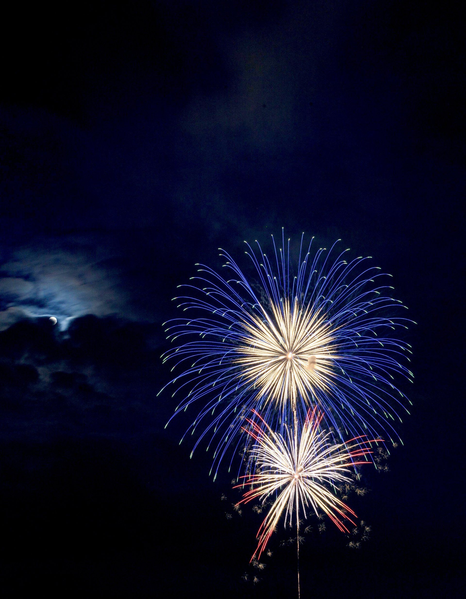 A fireworks display with a full moon in the background