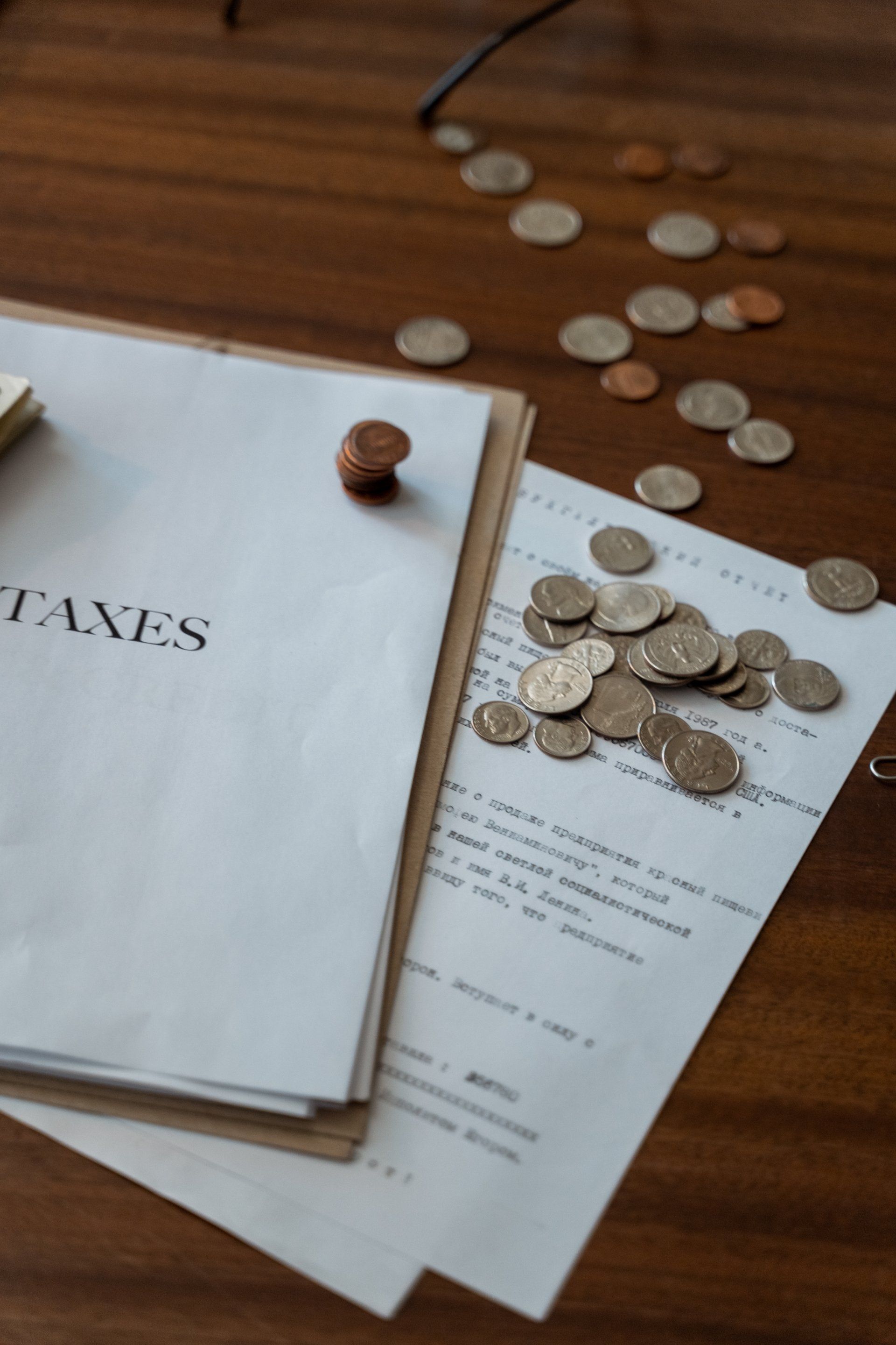 A bunch of coins are on a piece of paper that says taxes