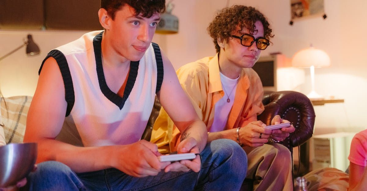 Two young men are sitting on the floor playing a video game.