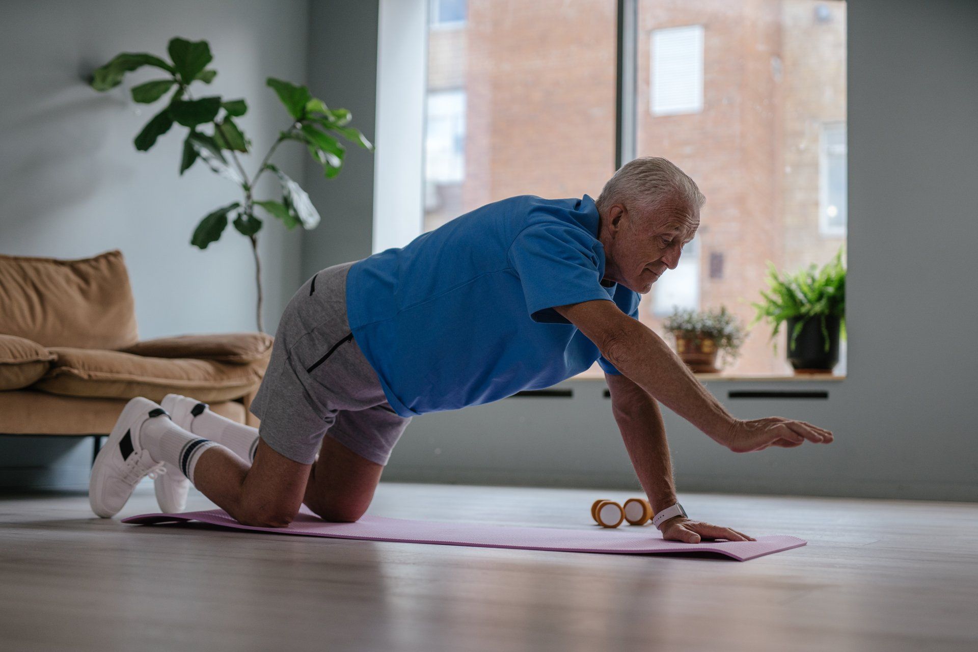 Happy elderly man doing exercise on a mat