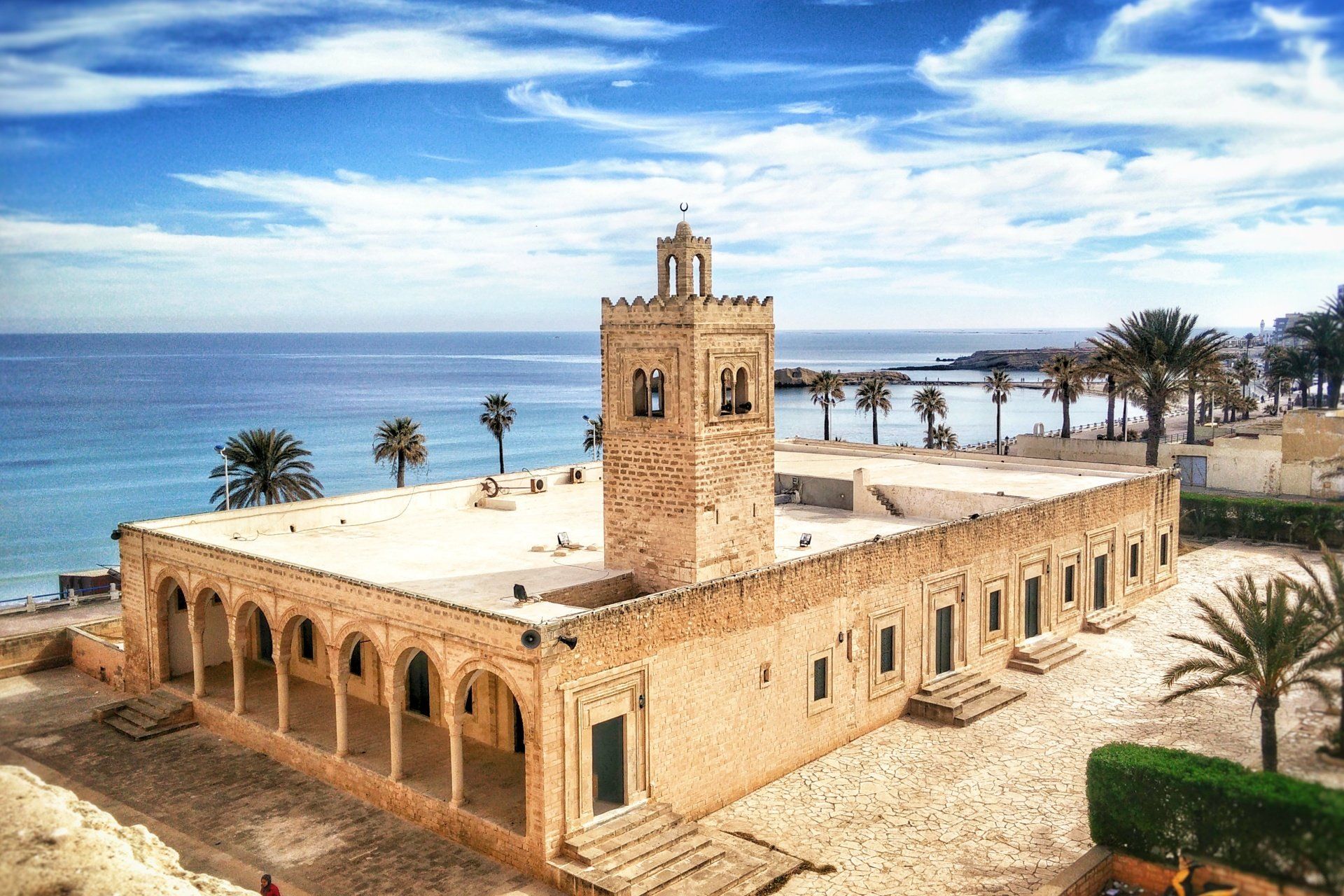 An aerial view of a mosque next to the ocean.