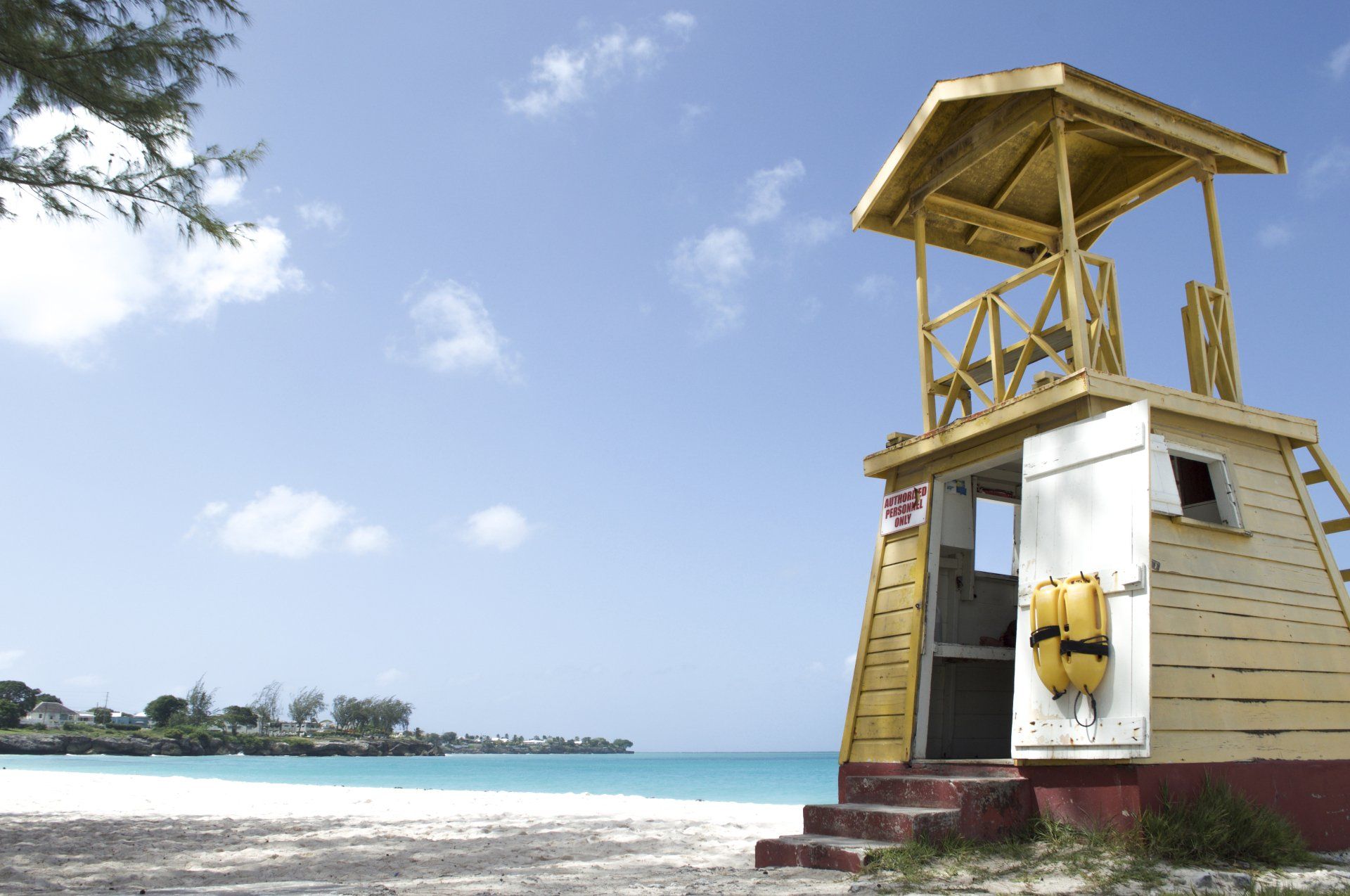 A lifeguard tower sits on the beach near the ocean