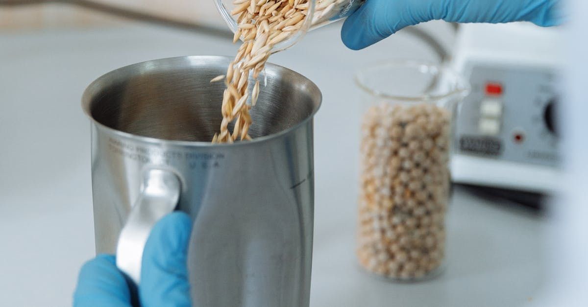 A person is pouring grains into a metal cup.