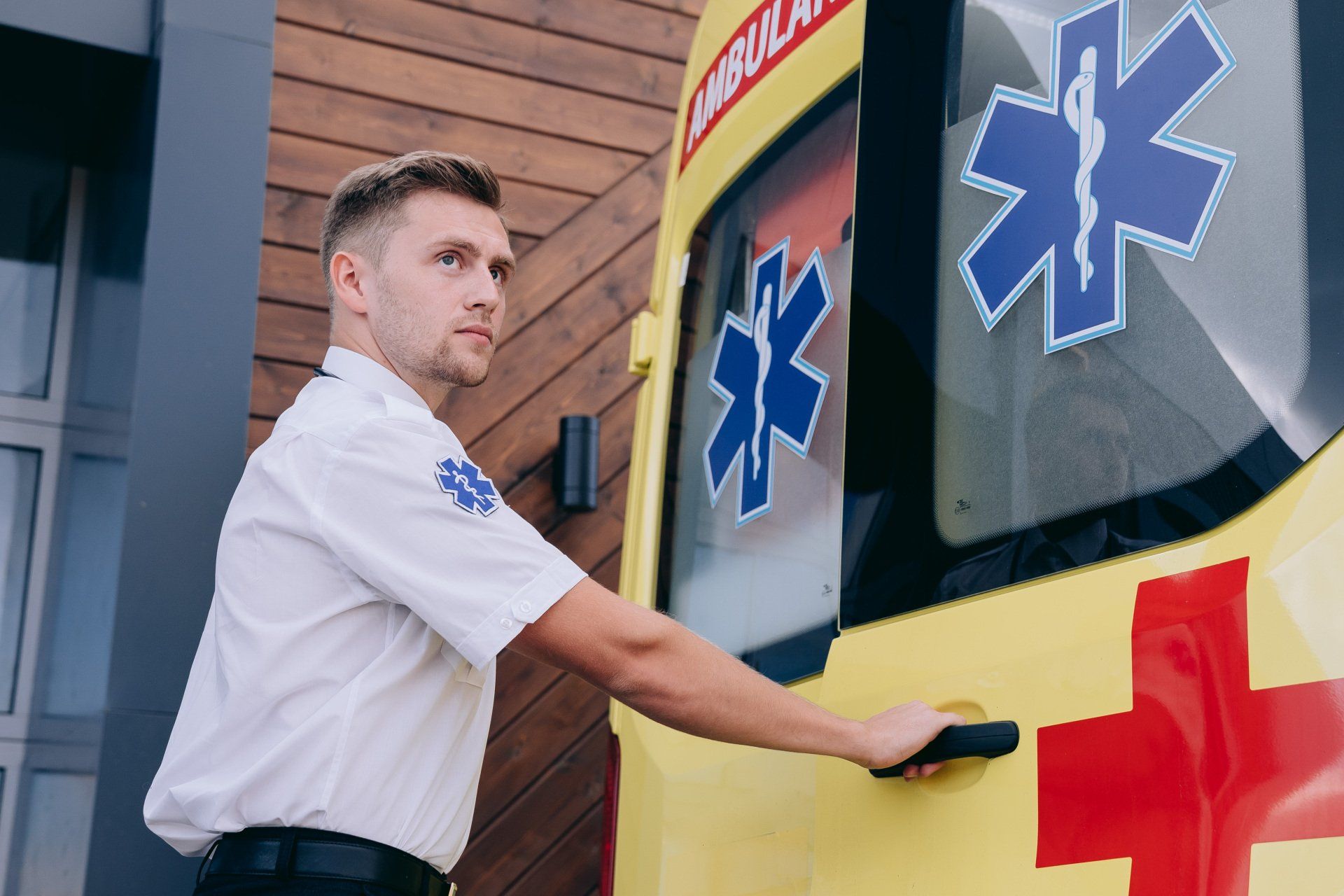 A man is opening the door of an ambulance.