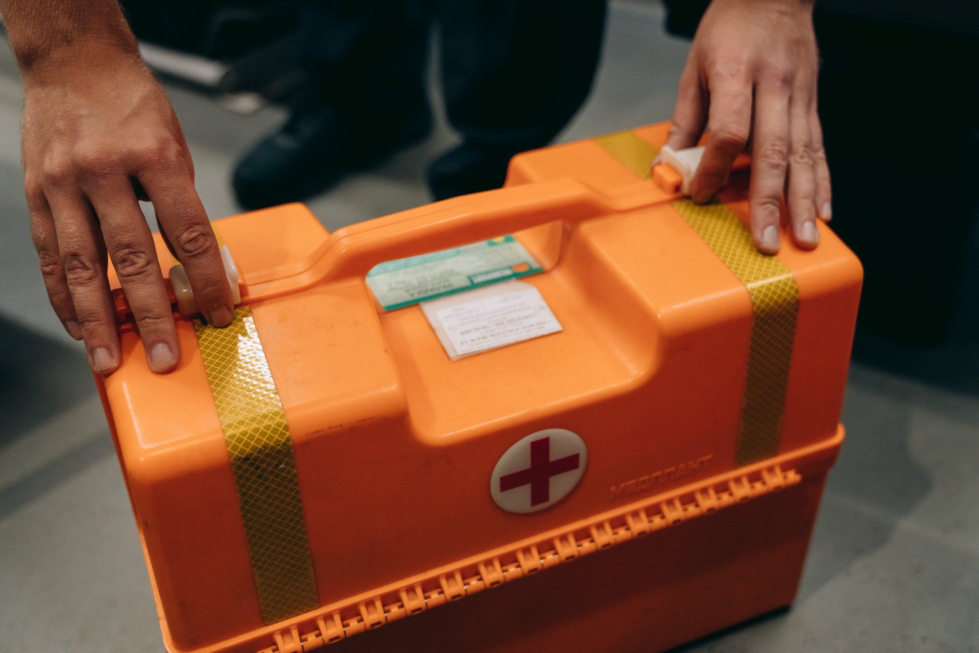 A person is holding a first aid kit in their hands.