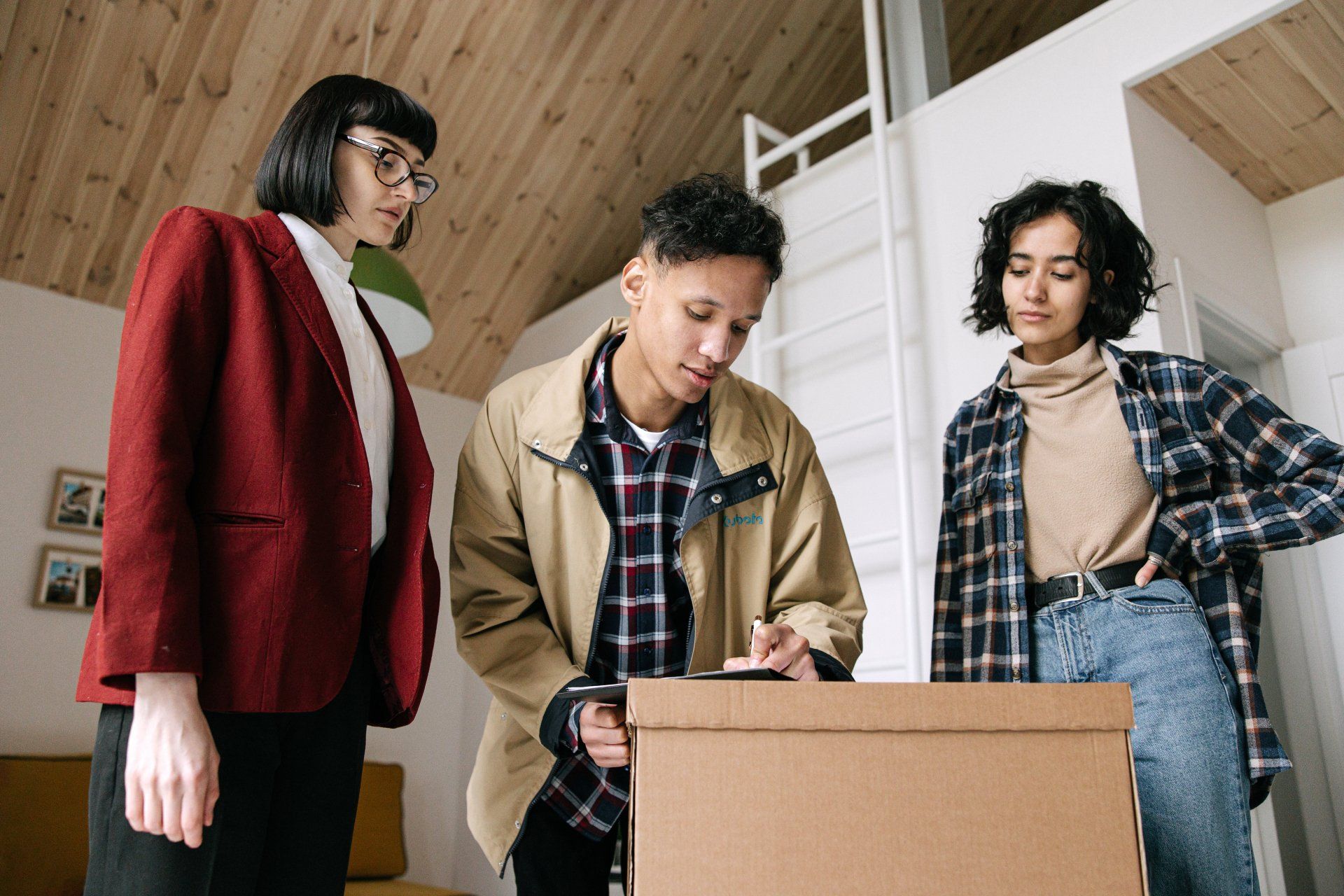 A group of people are standing around a cardboard box.