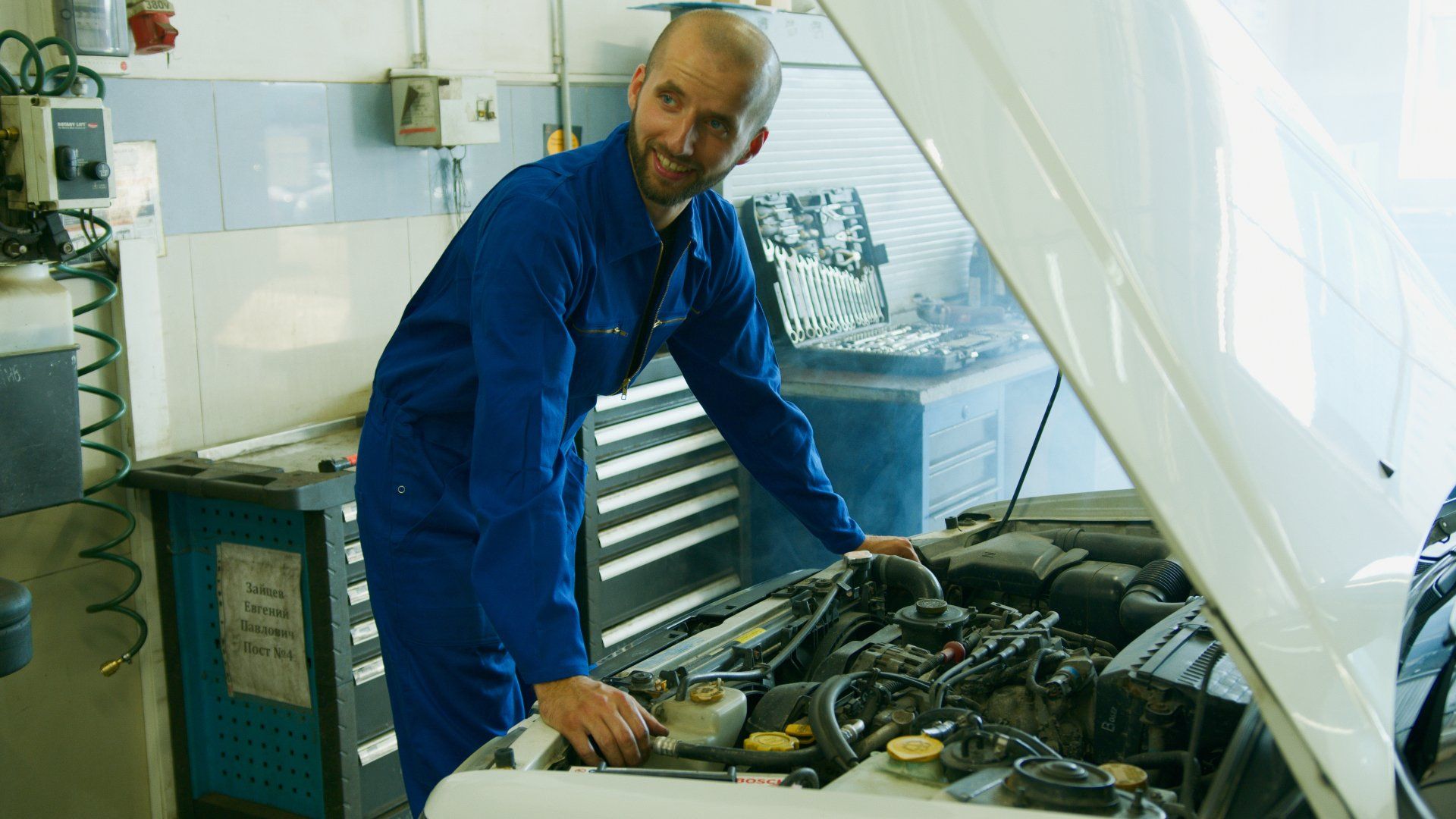 a mechanic is working on the engine of a car