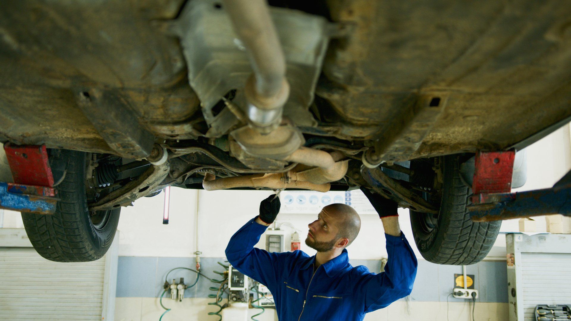 A mechanic is working under a car | Velocity Auto Sales