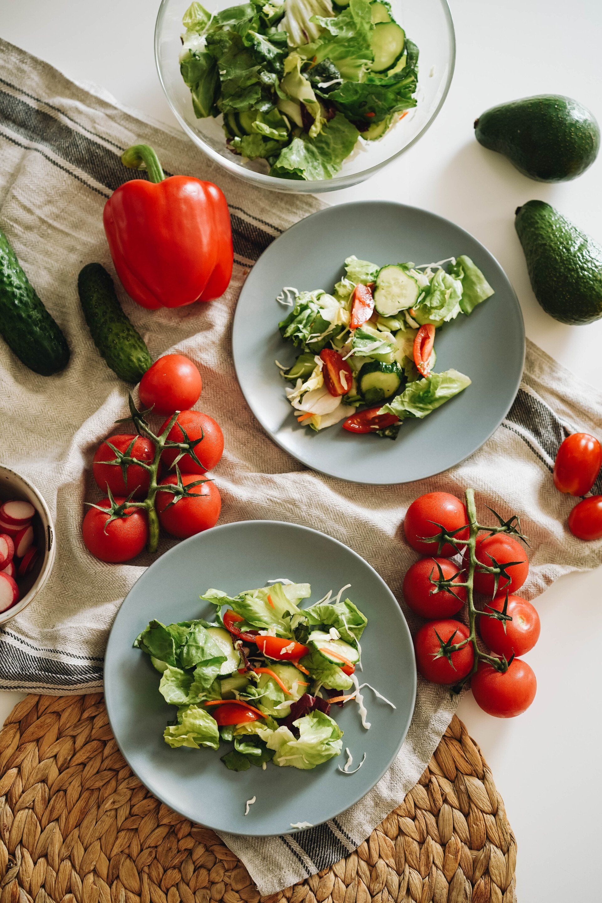 A table topped with plates of salads and vegetables.