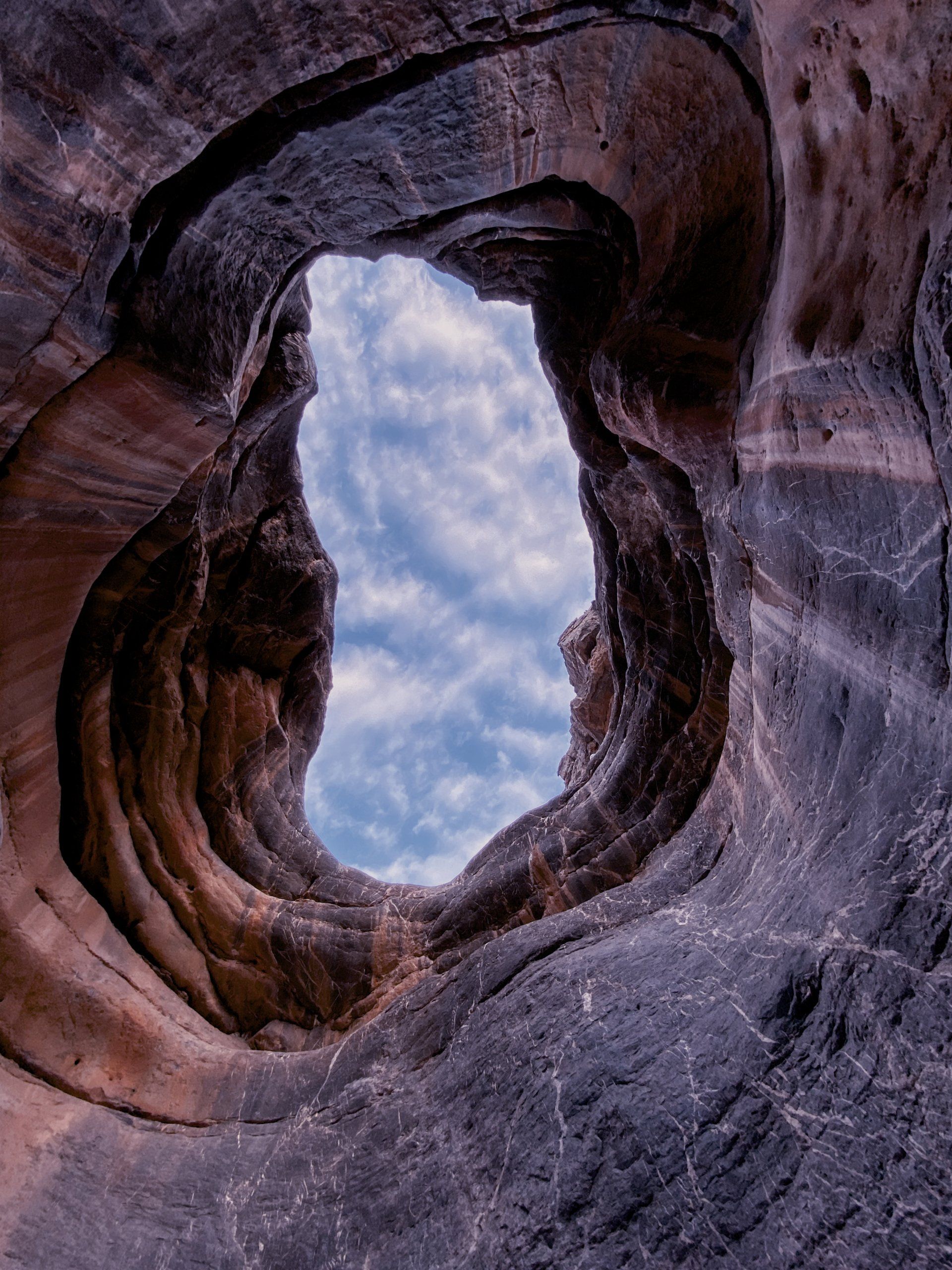 Looking through a hole in a rock formation at the sky