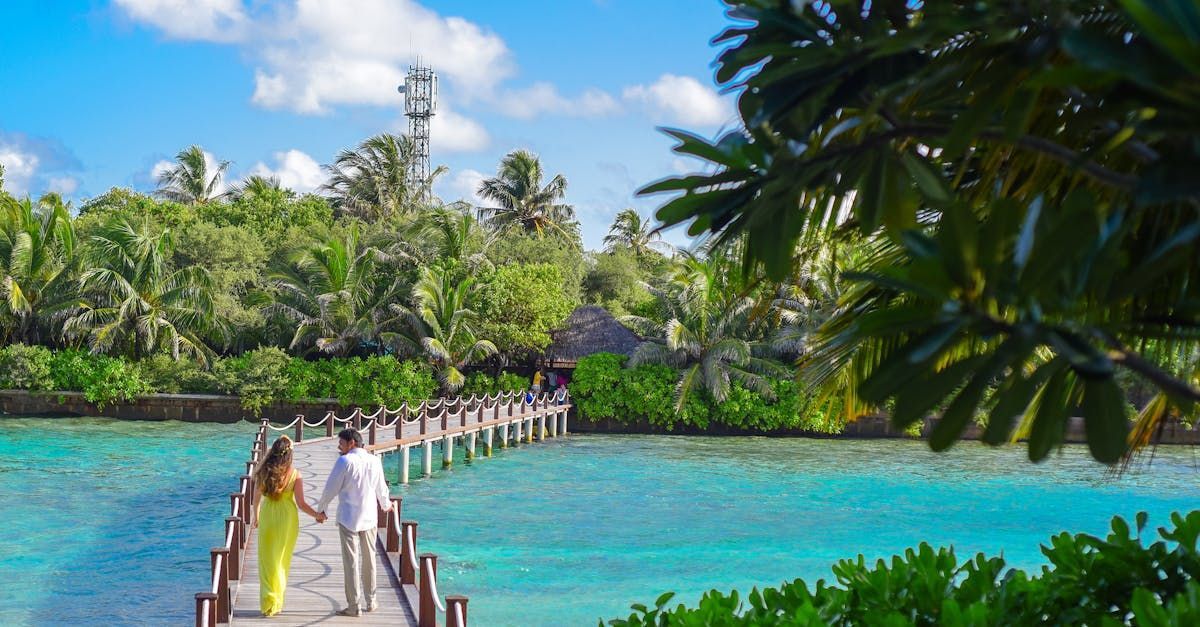 A man and a woman are walking on a pier overlooking the ocean.