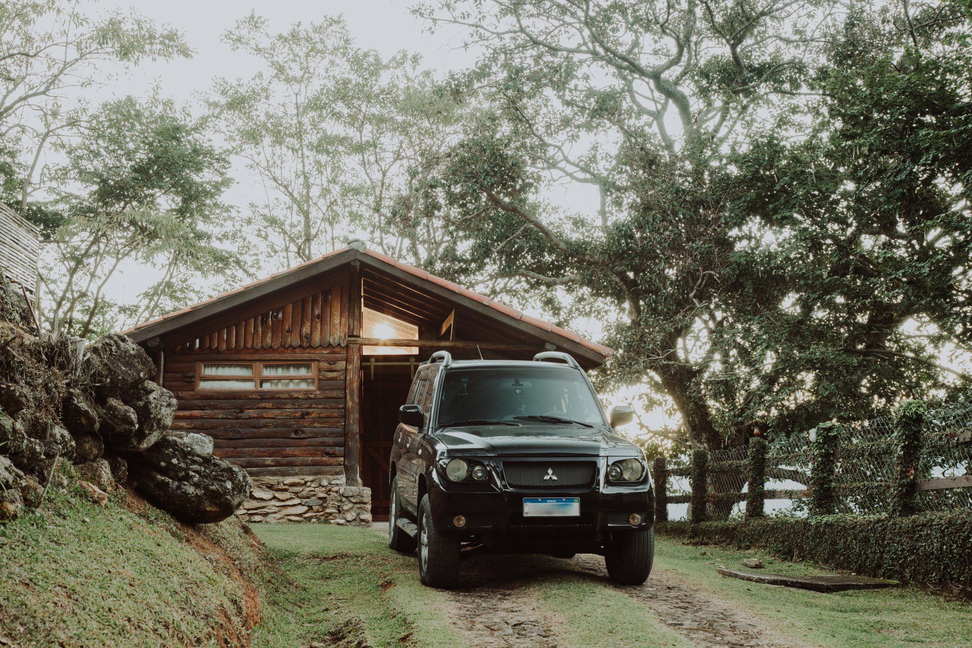 Black Toyota Landcruiser parked in front of wooden cabin