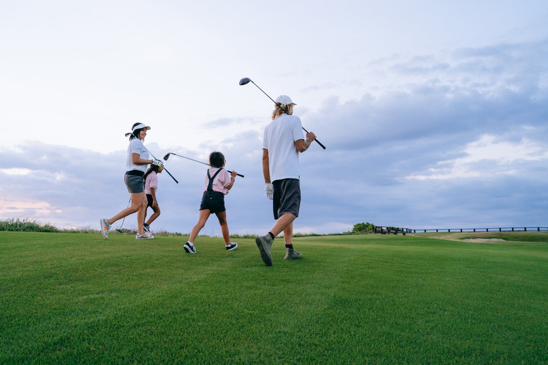 a family on a golf course holding a golf club