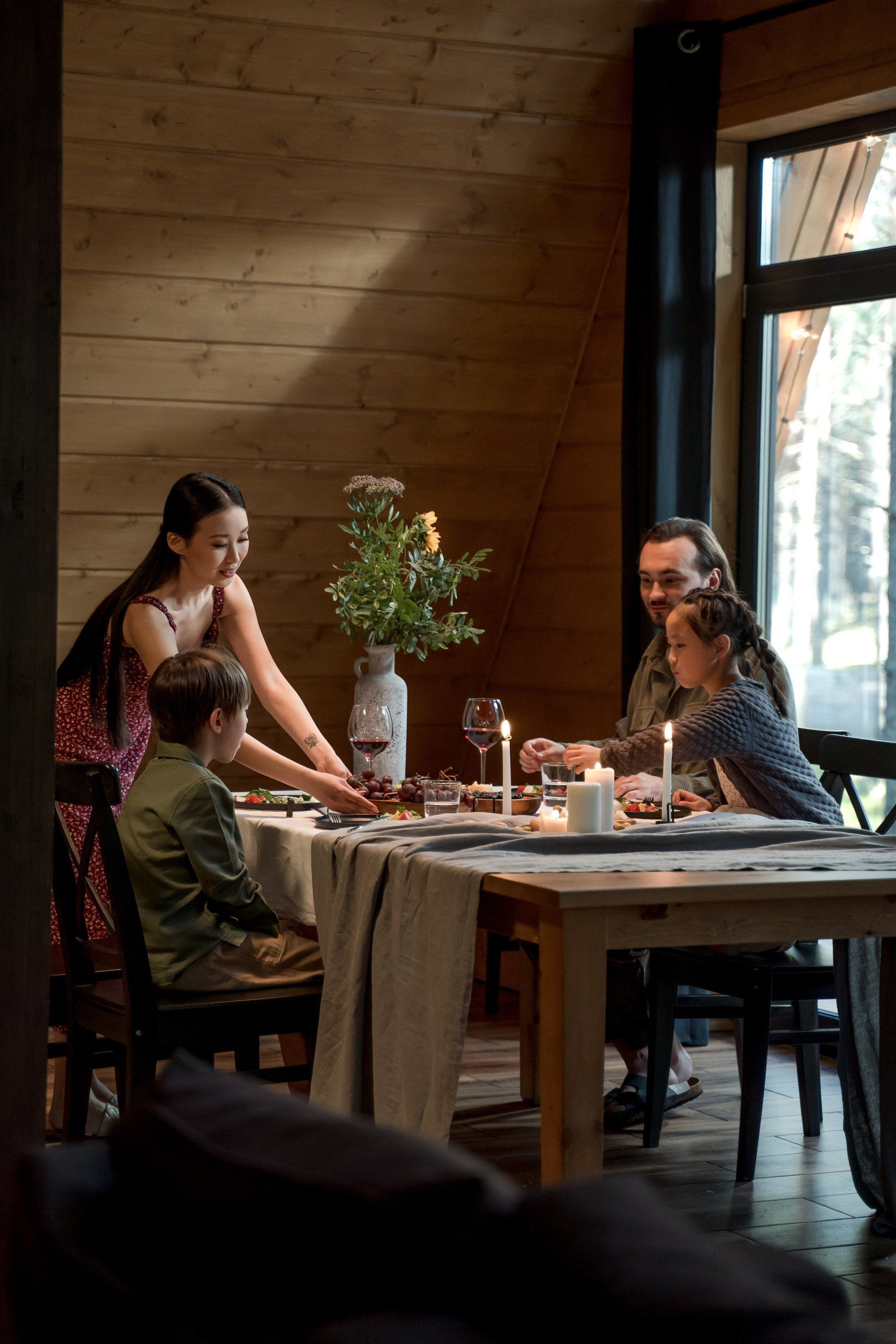 a family is sitting at a table eating dinner together .