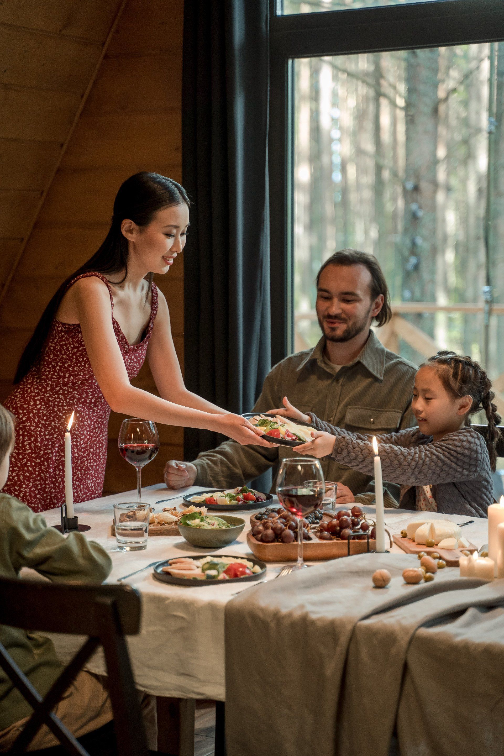 A woman is serving food to a family at a table.