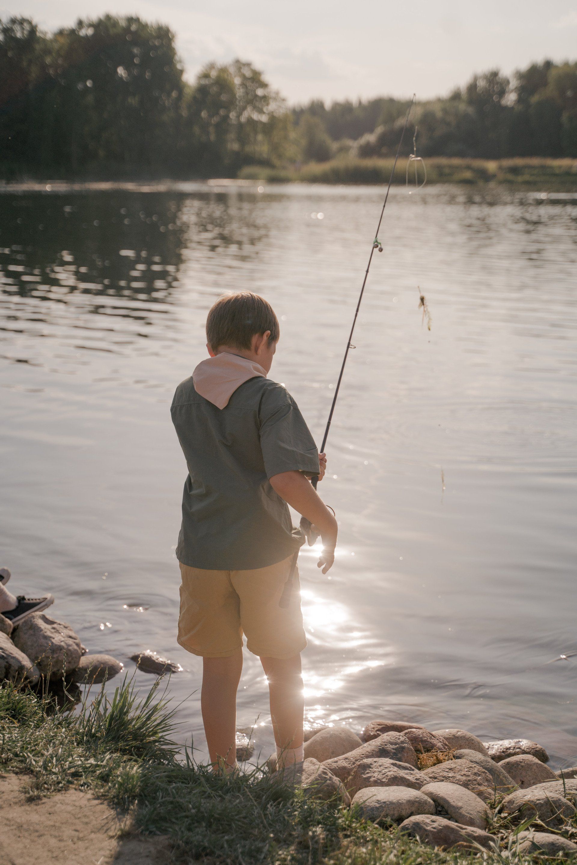 Kid fishing on the edge of a lake