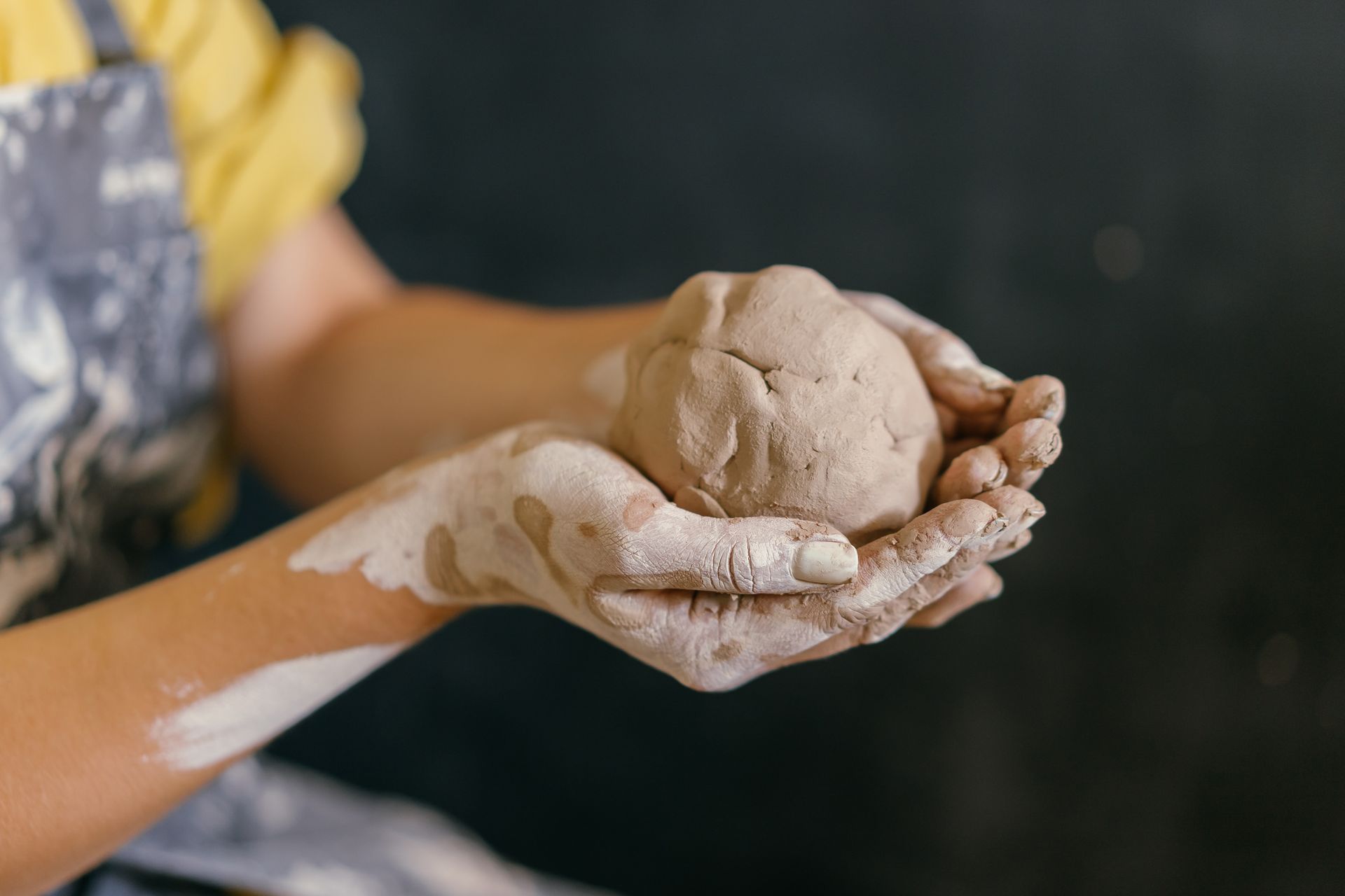 Artist's hands holding a lump of clay ready to be sculpted.