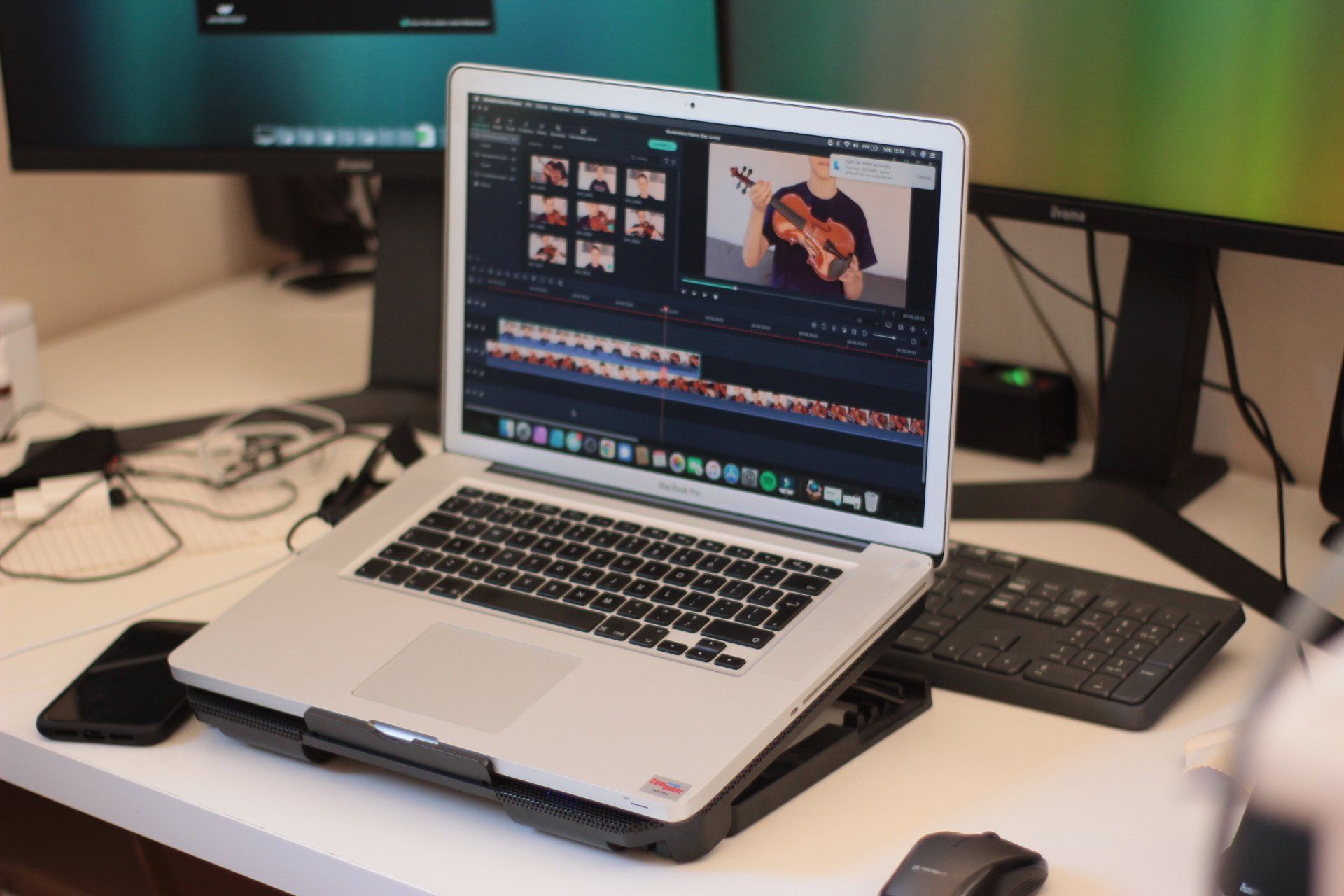 A laptop is sitting on a desk next to a keyboard and mouse