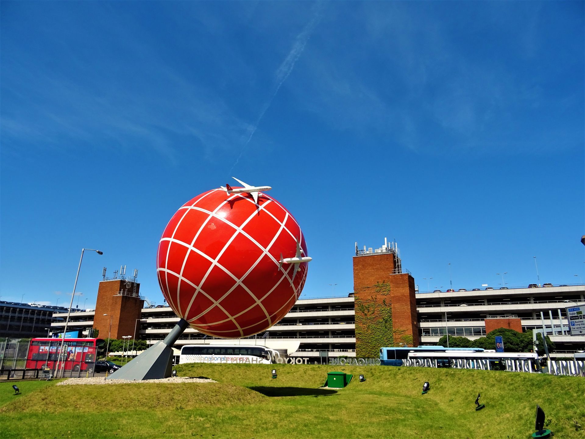 A large red globe with a plane on top of it