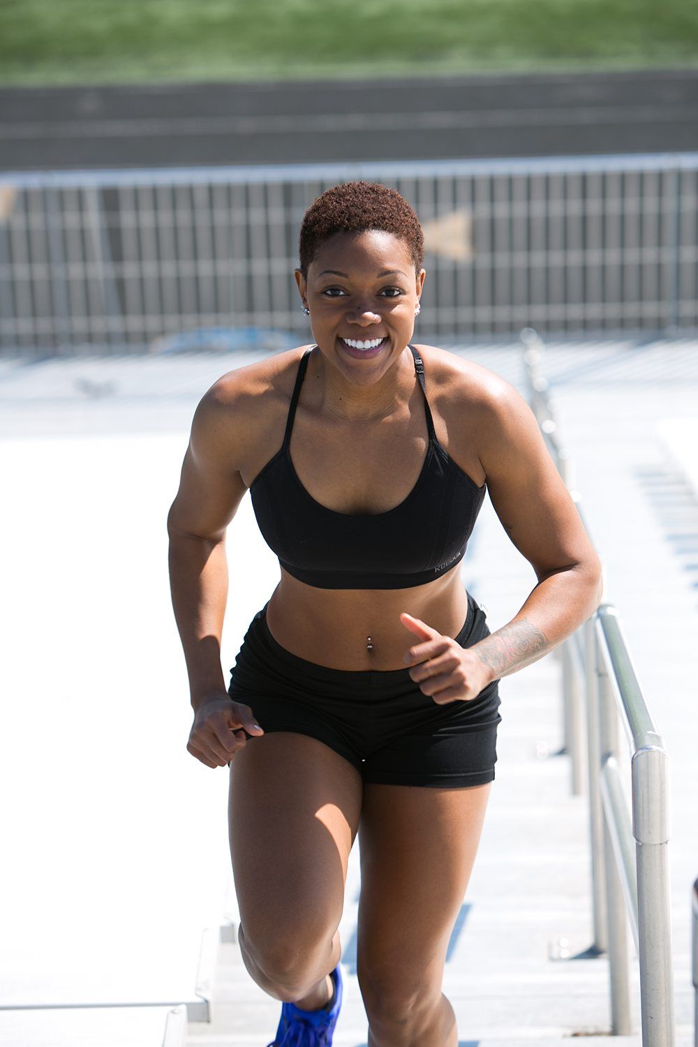 young black woman exercising running up stadium bleachers