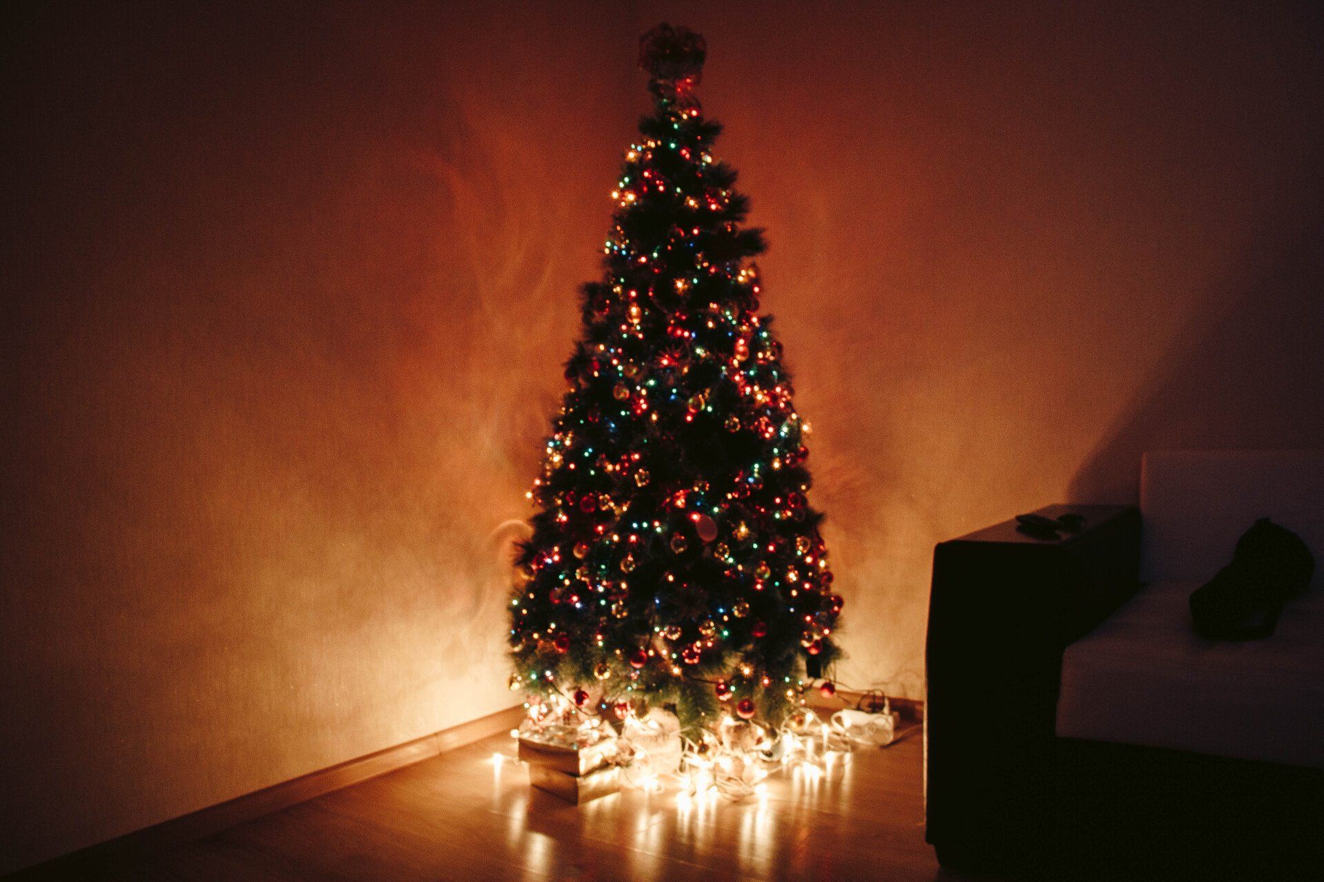 a christmas tree is lit up in a dark room
