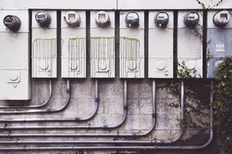 A row of electrical meters on a brick wall