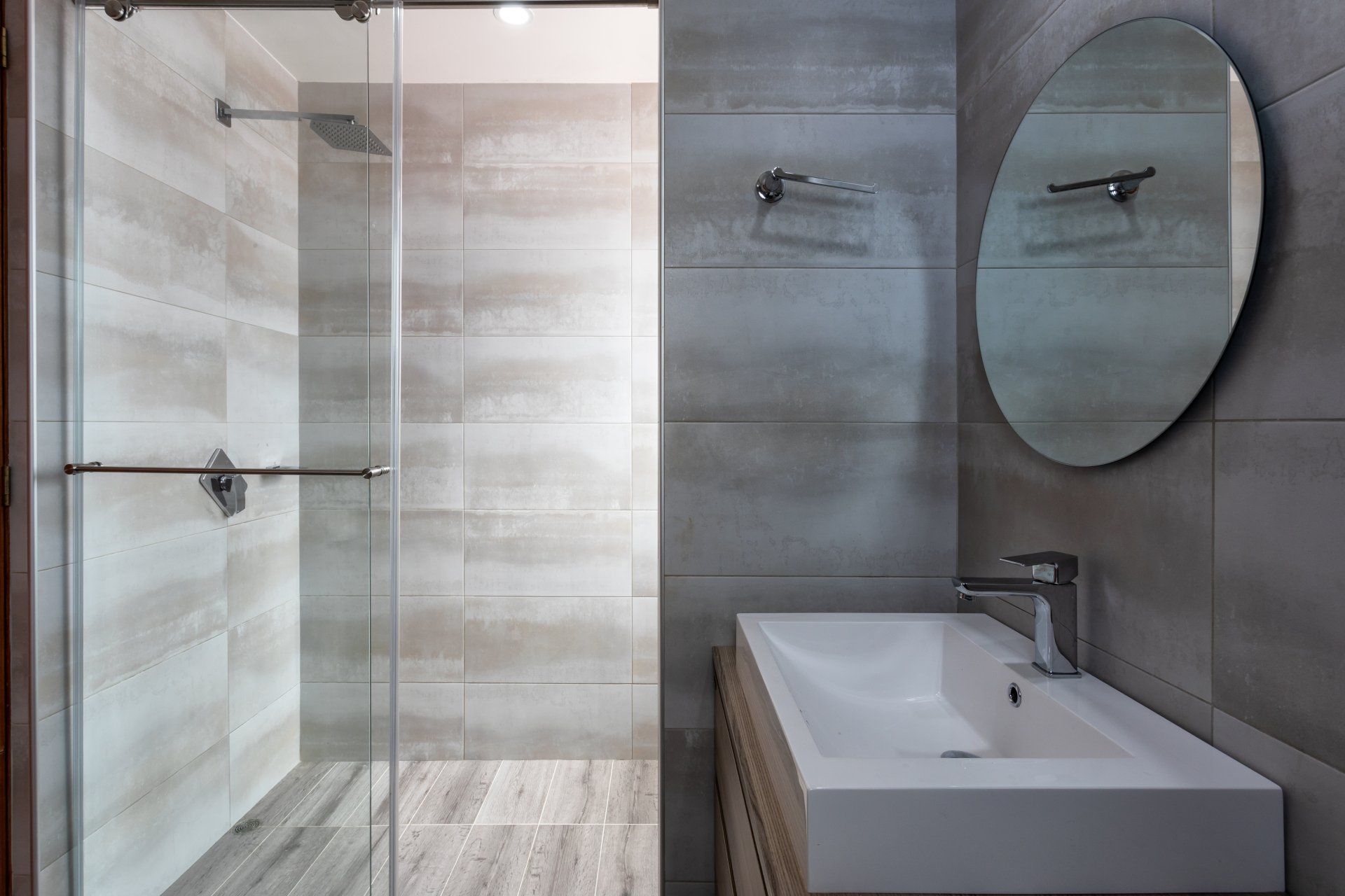 A bathroom with a sink , shower , and mirror.