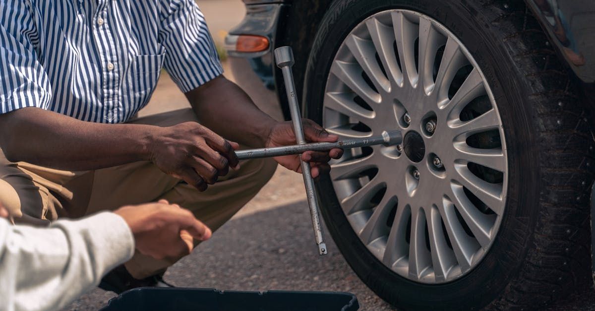 A person is working on a car engine with a wrench.