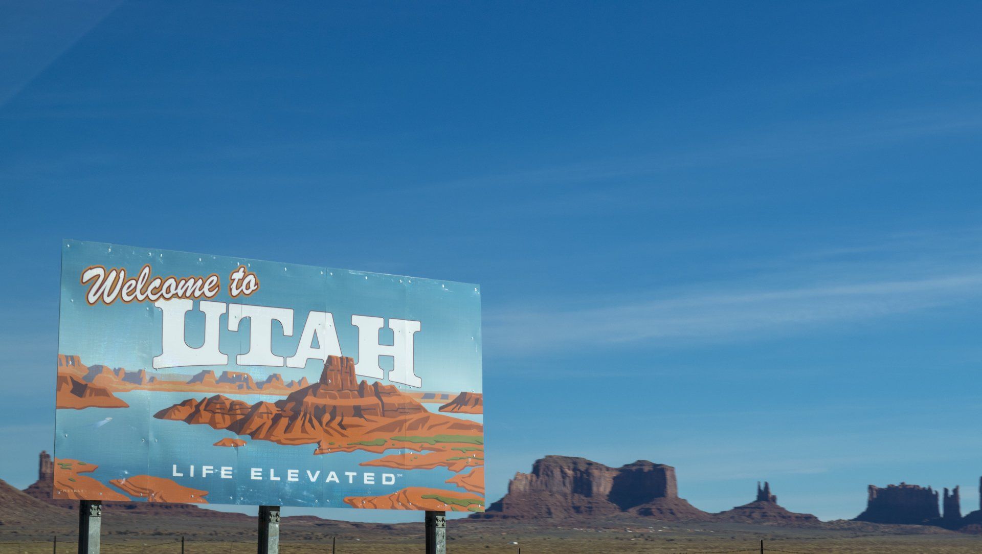 un cartello di benvenuto nello Utah con le montagne sullo sfondo